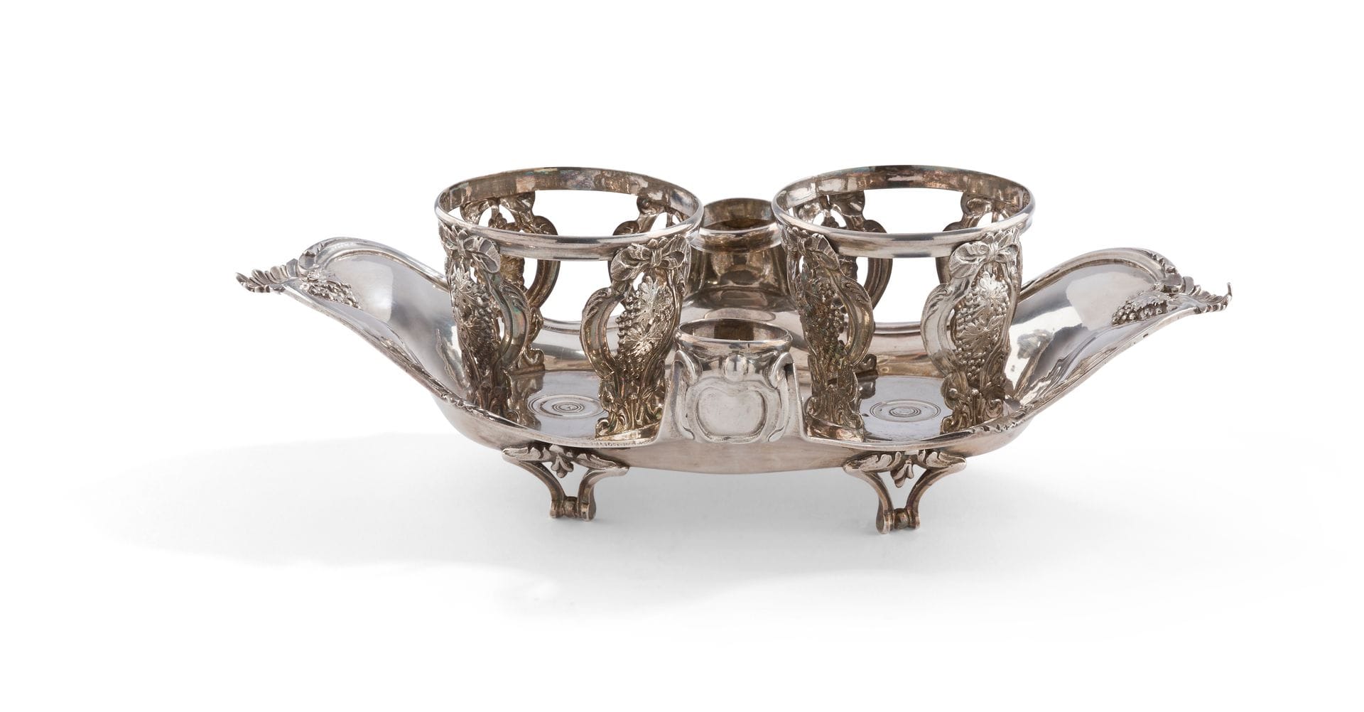 PARIS 1785 - 1786
Silver oil and vinegar cruet resting on four feet with openwork scrolls, the body with contours and foliage, the ends underlined by clusters of grapes and shells in recall on the supports of the flask holders in frames of knotted ribbons.
Master goldsmith : Louis-Joseph MILLERAUD BOUTY, received in 1779
Weight : 562 g - length : 28,5 cm - width : 16,2 cm