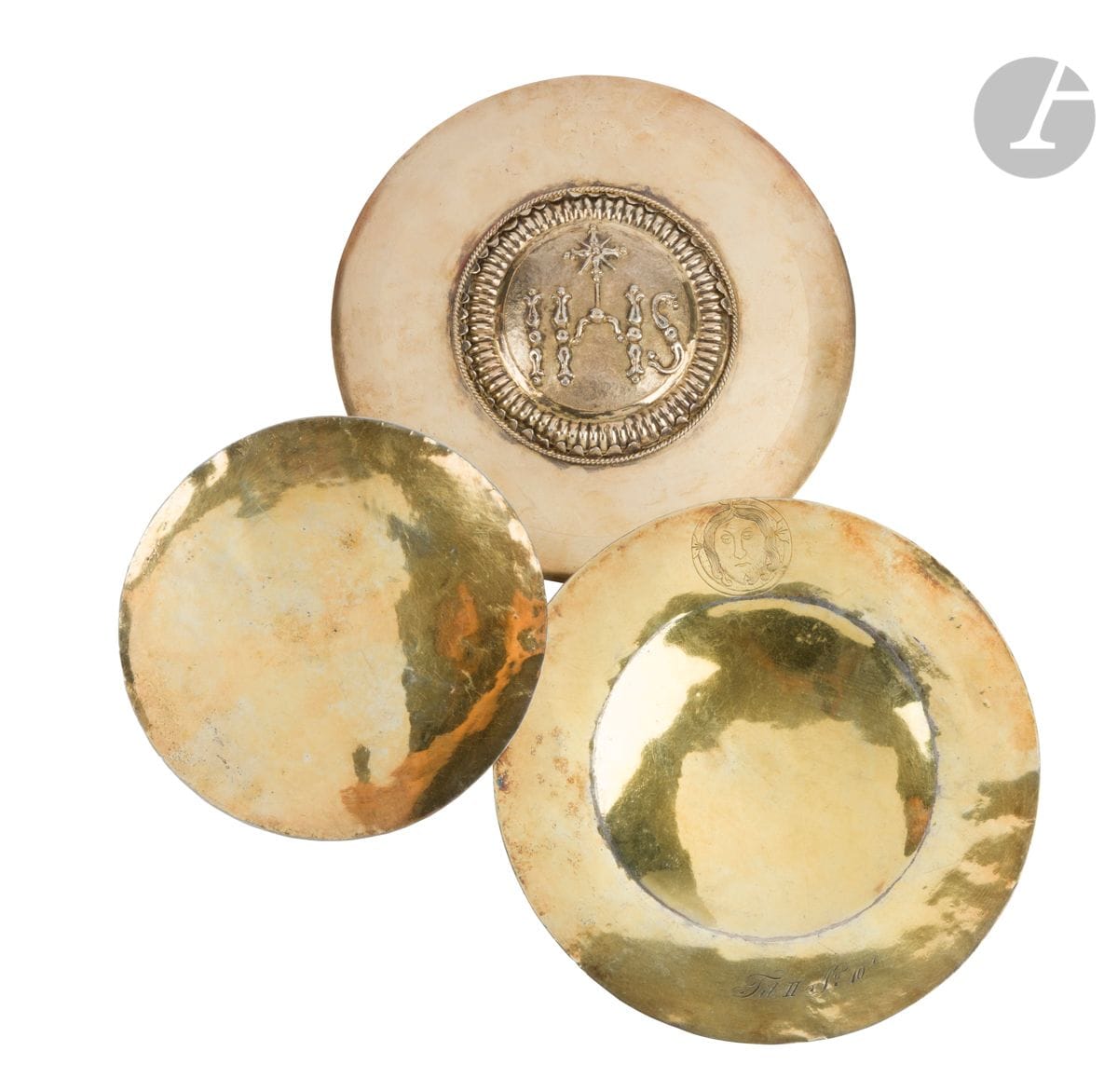 Lot de deux patènes en vermeil : 
- l’une à motif central « IHS » dans un encadrement de godrons, de lames (manques) et cordelette torse. 
Contrôlée au cygne
Poids : 179 g - diamètre : 16,8 cm
- la seconde gravée en bordure de la tête du Christ de face et de la mention FIT II N°10.
Prusse 1809
Poids : 170 g - diamètre : 17 cm
On y joint le centre d’une troisième patène, contrôlée au cygne.
Poids : 72 g - diamètre : 13,4 cm
Poids total : 421 g