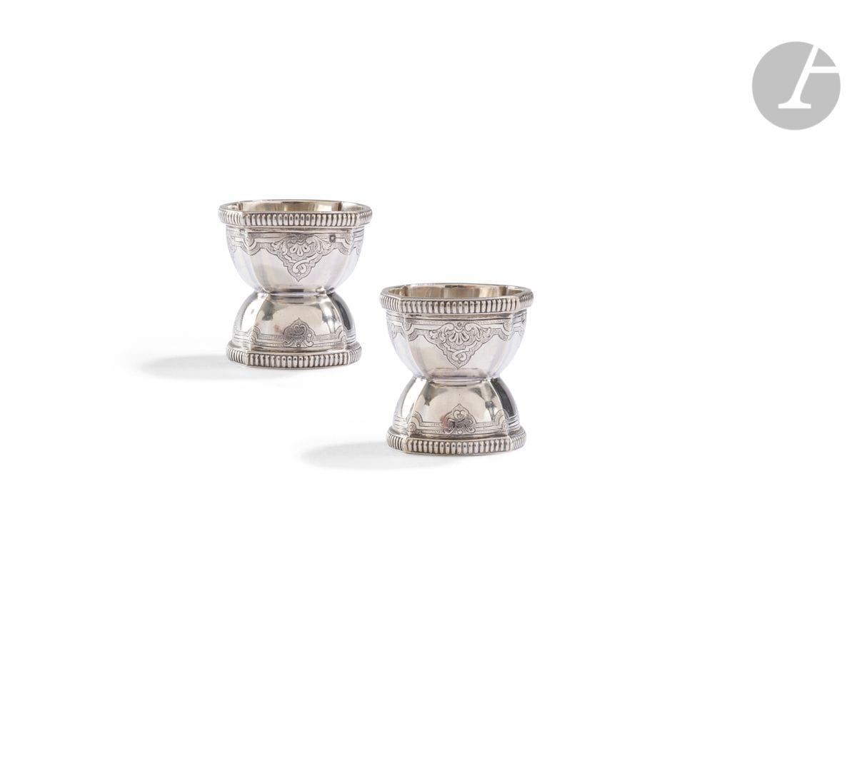 FRANCE DÉBUT DU XXe SIÈCLE
Paire de coquetiers en argent, modèle diabolo à contours bordés de godrons prolongés d’une gravure d’inspiration régence.
Poinçon minerve
Pas d’orfèvre
Poids : 118 g - hauteur : 4,6 cm
