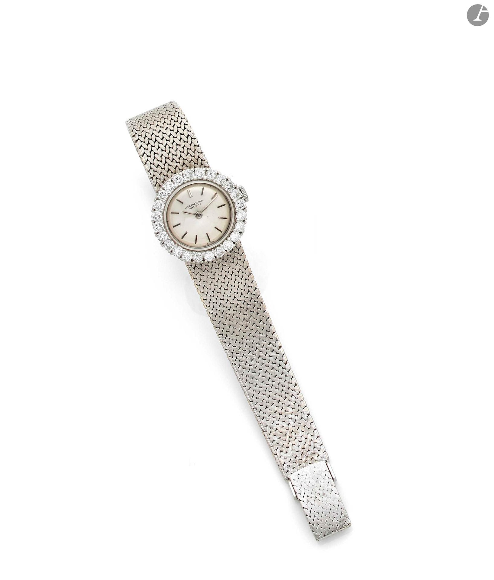 IWC. Années 50 Montre bracelet de dame en or gris 18K (750) et diamants. Boîtier rond et lunette sertie de diamants. Cadran argenté avec index bâton appliqués. Mouvement mécanique, cal. 431. Bracelet intégré en or gris satiné avec boucle simple non signée. Cadran, boîtier et mouvement signés. Numérotée 1590018 Diamètre : 21 mm - Longueur : 15 cm Poids brut : 40,2 g
