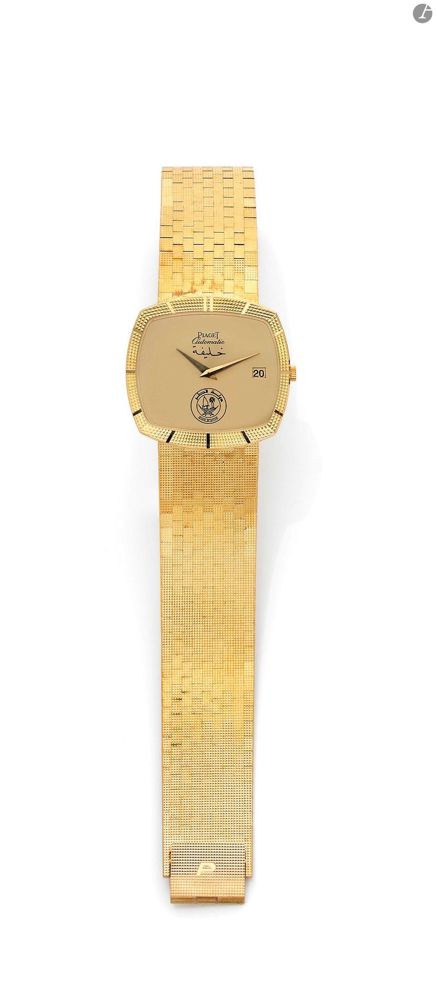 PIAGET. QATAR. Années 70. Montre bracelet « clous de Paris » en or jaune 18K (750) offerte par le califat du Qatar. Boîtier coussin avec lunette et tranche à motif « clous de Paris ». Cadran doré orné de l’emblème du Qatar, aiguilles feuille et date. Mouvement automatique. Bracelet intégré en or jaune à motif « clous de Paris » et boucle simple siglée P. Signée et numérotée 286548 Diamètre : 32 mm - Longueur : 20 cm Poids brut : 112,8 g