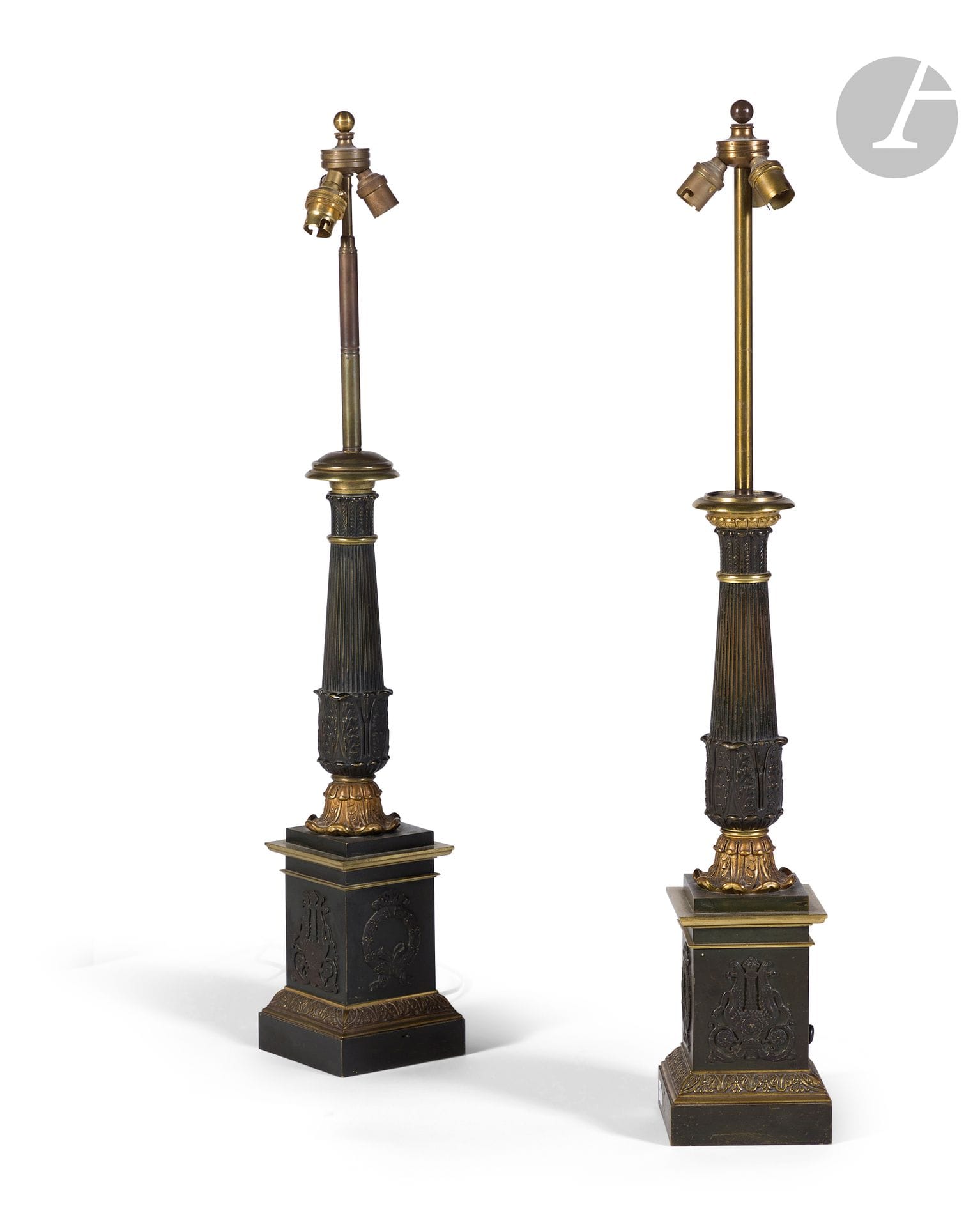 Paire de lampes en bronze patiné et bronze doré, le fût à décor de cannelures et feuillages, reposant sur une base à lyre stylisée, signée sur un carteL. : Place des Victoires n° 1 : Gotten, Inventeur breveté ; (montée à l’électricité, petites différences dans le montage).
vers 1840.
H. : 78 cm