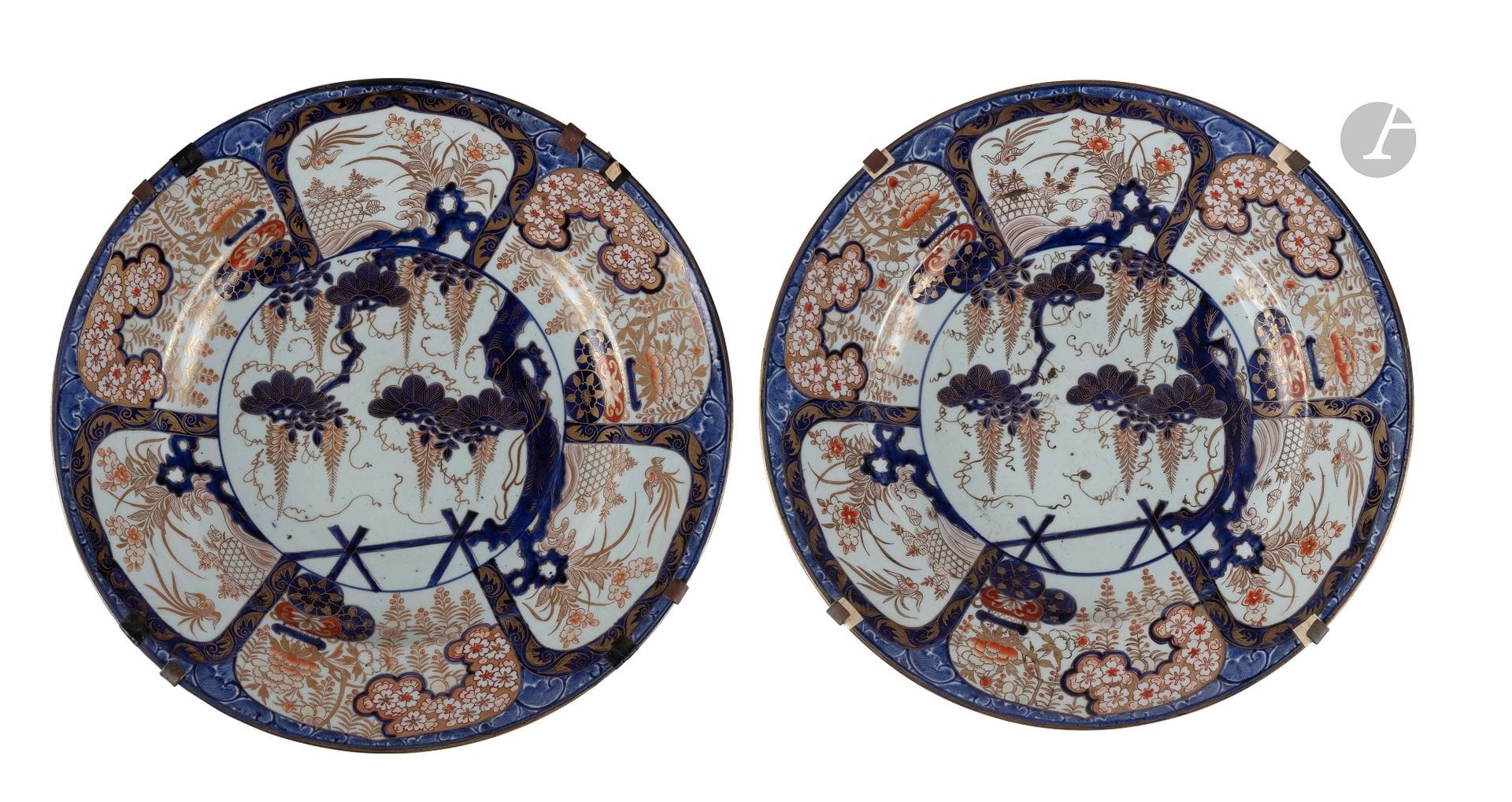 Japan
Pair of large porcelain dishes with blue, red and gold Imari decoration of flowering shrubs in the center and on the wing of birds, baskets of flowers and shrubs in compartments.
Early 18th century. 
D. : 55 cm