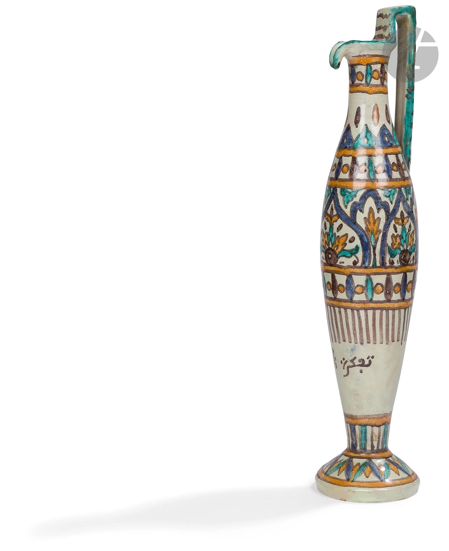 Haute aiguière chianti, Tunisie, Nabeul, première moitié du XXe siècle
Verseuse à panse fusiforme sur piédouche convexe, la lèvre pincée et l’anse angulaire. En faïence à décor d’arcatures abritant des motifs floraux, des frises de fuseaux ou de stries verticales de part et d’autre. L’anse striée de brun, le pied à décor de chevrons. Inscription en arabe sur la partie inférieure de la panse “Tadhakra Nabeul” / “Souvenir de Nabeul” et estampilles “Poterie de Nabeul” et “D. Matteis, Tunis, avenue de France” sous le pied.
Hauteur : 53 cm

A Tall Pottery Ewer, Tunisia, Nabeul, first half of the 20th century 

La poterie artistique de Nabeul : atelier de Verclos (1920-50) (lots 202 à 209) - Collection Samuel Hedri (lots 174 à 212).