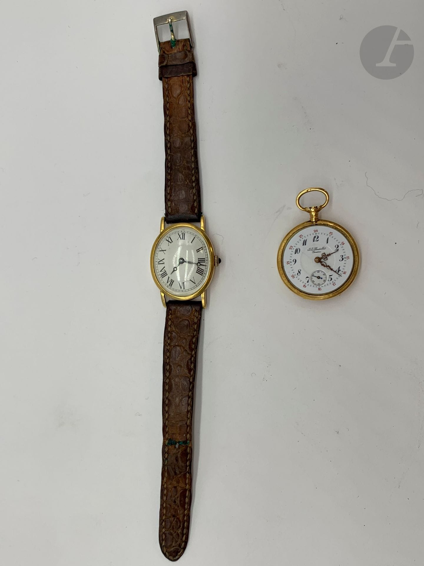 2 montres en or: - Montre de col en or (18K). JJ Badollet - Genève. Poids brut: 18 g (double paroie - manque le verre) - Montre bracelet de dame en or (18K) bracelet cuir. Poids brut: 20,2 g