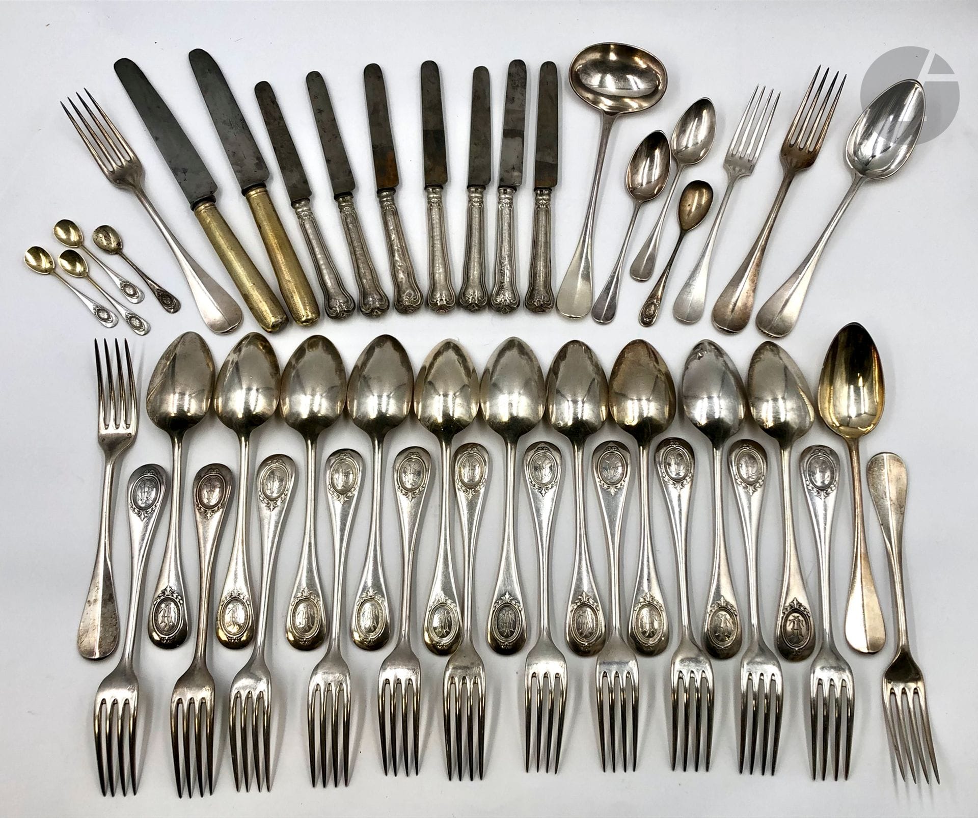 Partie de ménagères en argent dépareillée. Poids brut : 2904 g - 12 couverts - 4 fourchettes - 3 cuillères à café - 4 pelles à sel - 7 couteaux à entremets. On joint des couteaux de table en métal argenté.
Poids net (sans les couteaux): 2647 g