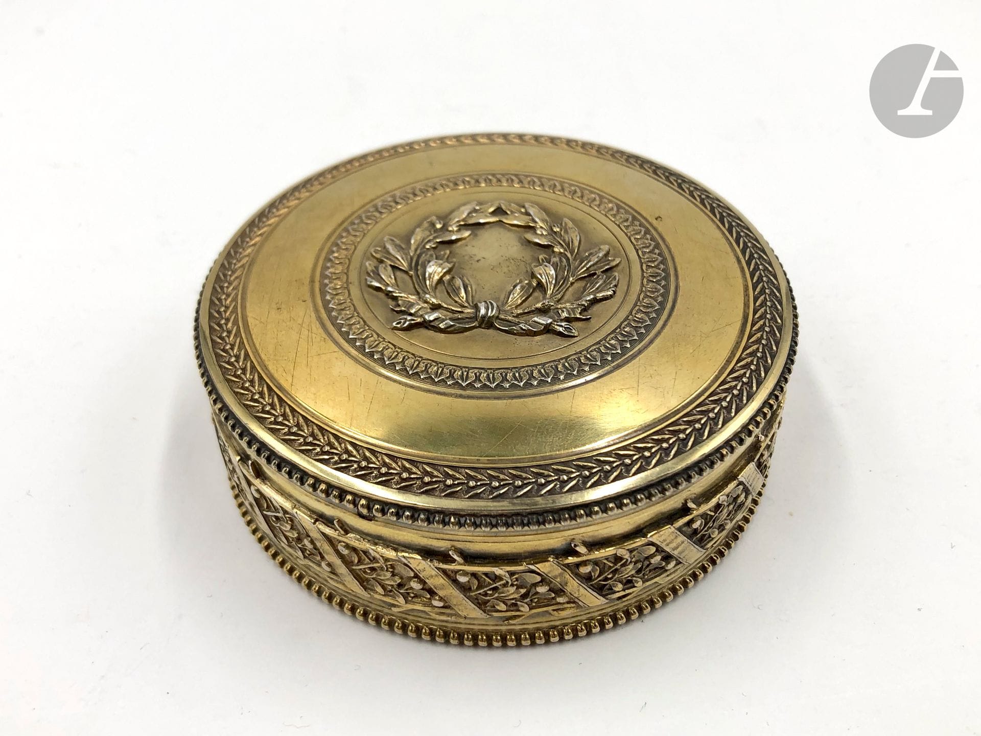 Boîte circulaire en vermeil de Style Louis XVI. Poids : 180 g décors de frises de rubans et d une couronne de laurier. D : 9 cm Poinçon Minerve.
