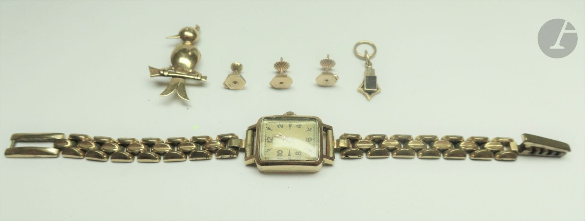 Montre bracelet de dame en or, bracelet en métal doré. Poids brut: 35,7 g On joint 3 montures de puces d oreilles, 1 broche oiseau et un pendentif en or. Poids brut: 6 g