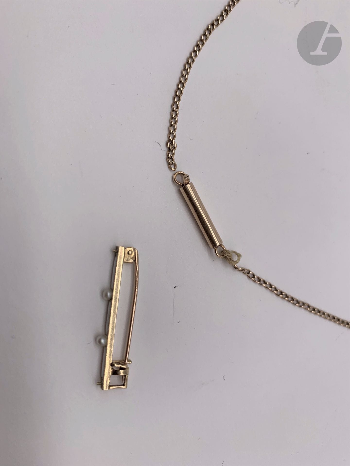 1 Chaîne en or (14K)(accidents). Poids: 5,7 g et 1 épingle à nourrice de bébé, en or (18K), émail blanc et perlettes. pOids brut: 1,6 g