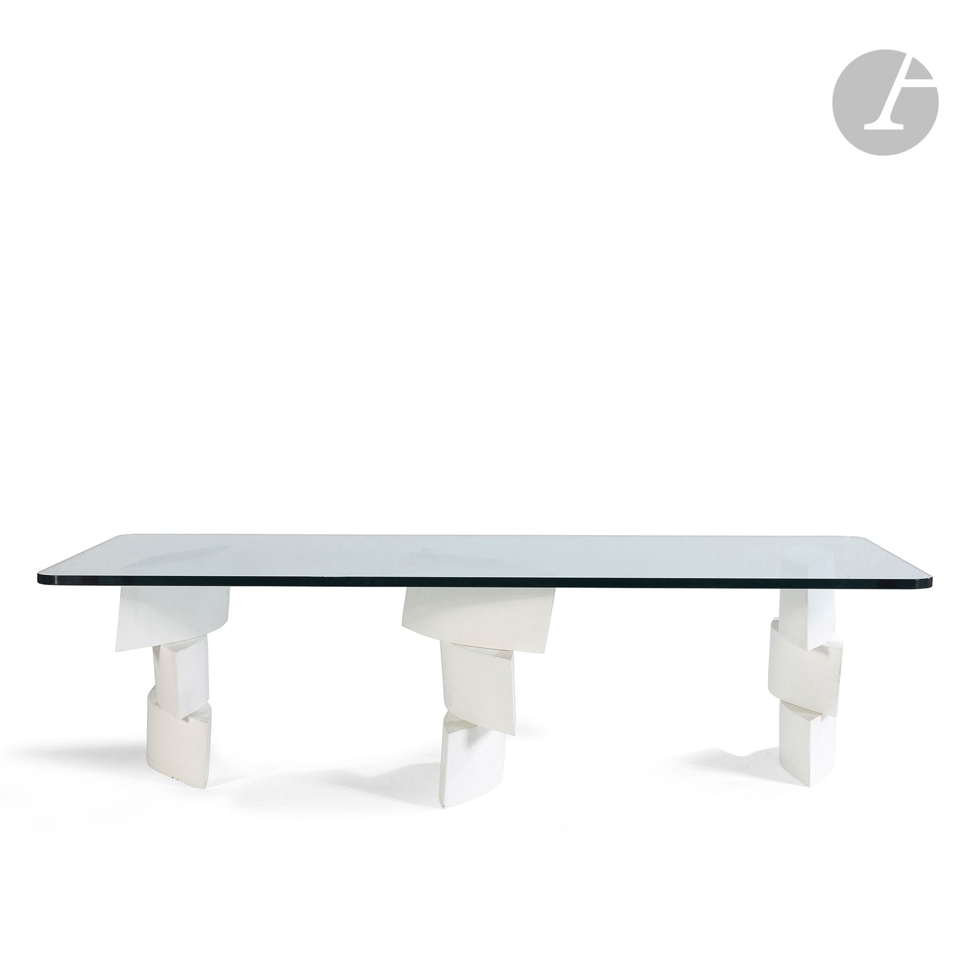 YVES DE LA TOUR D’AUVERGNE (NÉ EN 1927)
Ellipse (variante), vers 1994
Table basse. Le piètement constitué de 3 plots en poudre de marbre et résine évoquant des navettes elliptiques superposées. Le dessus rectangulaire aux angles arrondis en dalle de verre clair. Édition limitée. Un pied marqué du monogramme de l’artiste. H. 42 cm – L. 160 cm – L. 75 cm
Provenance :
Succession M. et Mme B., Paris. D’une importante décoration réalisée par Isabelle Hebey dans les années 1980-1990 pour leur appartement du 8e arrondissement.
Bibliographie et œuvre rapport :
Pierre Daix (textes de) – Yves de la Tour d’Auvergne – Éditions Benteli, Berne, 2000. Une table Ellipse Pise reproduite page 148.