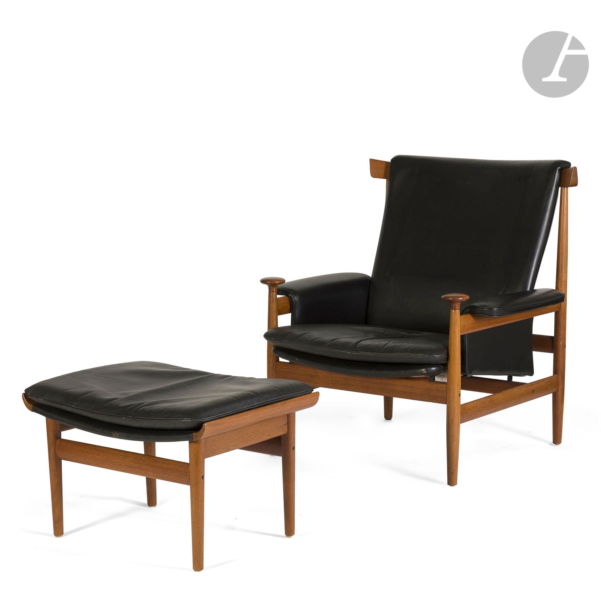 FINN JUHL (1912-1989) DESIGNER & FRANCE AND SON ÉDITEUR
Bwana, le modèle conçu en [1962]
Important fauteuil et son ottoman en teck. Les assises, le dossier et les manchettes d’accotoir tapissés de cuir noir. Édition ancienne. Des parties en cuir remplacées. Le fauteuil porte la pastille métallique d’éditeur et l’ottoman la marque au fer d’éditeur. Fauteuil : H. 81 cm – L. 87 cm – P. 79 cm – Ottoman : H. 39 cm – L. 64,5 cm – P. 49 cm
