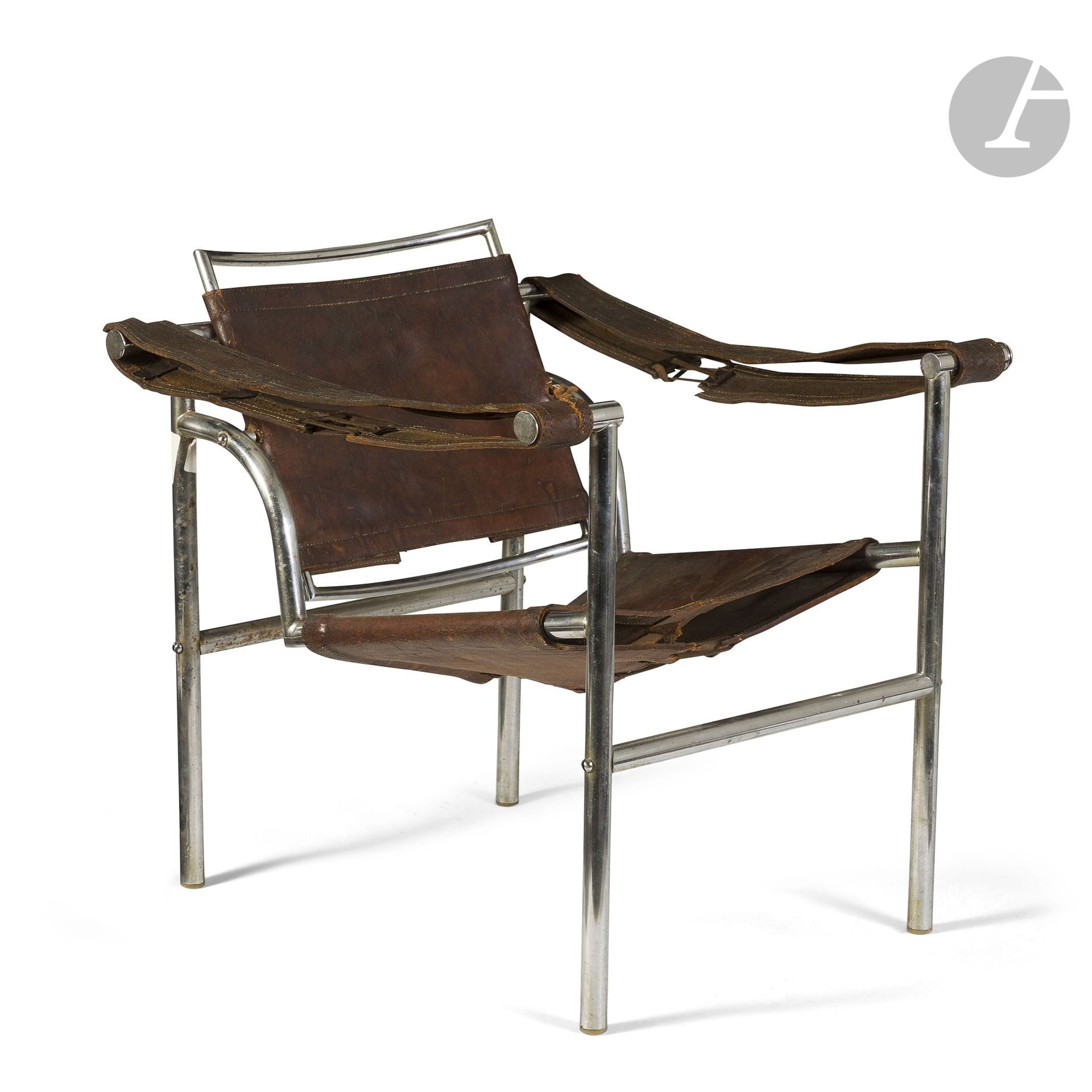 TRAVAIL DES ANNÉES 1960-70 D’APRÈS LE CORBUSIER (1887-1965) ET PIERRE JEANNERET (1896-1967) ET CHARLOTTE PERRIAND (1903-1999) CONCEPTEURS
D’après (et variante) du modèle LC1 créé vers [1928]
Fauteuil à dossier basculant. La structure en métal tubulaire chromé. L’assise, le dossier et les accotoirs en cuir brun tendu par lacets. Métal en état d’usage, parties en cuir très accidentées. H. 67 cm – L. 62 cm – P. 63 cm