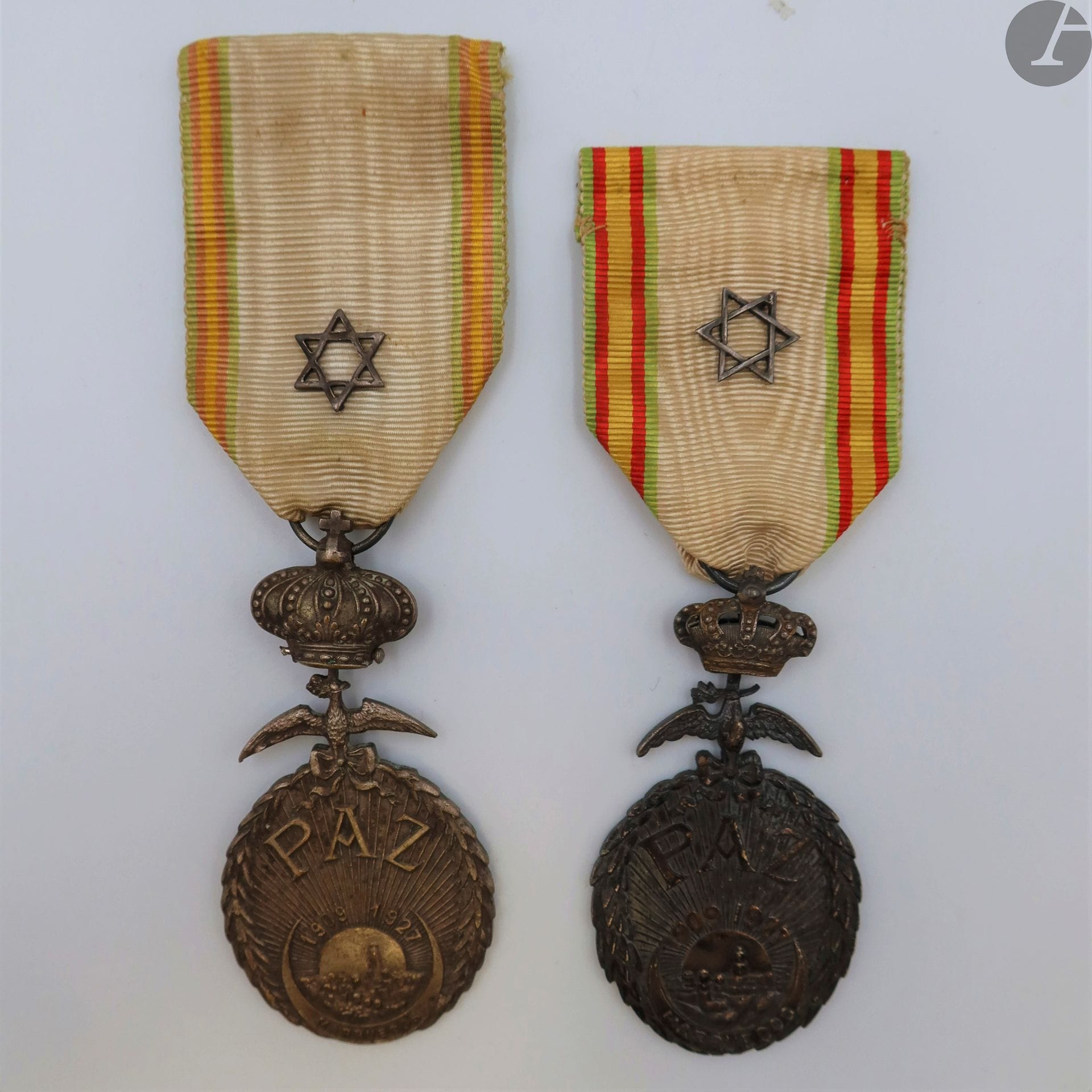 ESPAGNE 
MÉDAILLE DE LA PAIX DU MAROC (1927)
Deux médailles en bronze argenté. Deux modèles :
- à couronne pleine. Ruban à motif à la croix chérifienne.
- à couronne en partie ajourée. Ruban à motif à la croix chérifienne.
63 x 31 mm
T.T.B. à SUP.