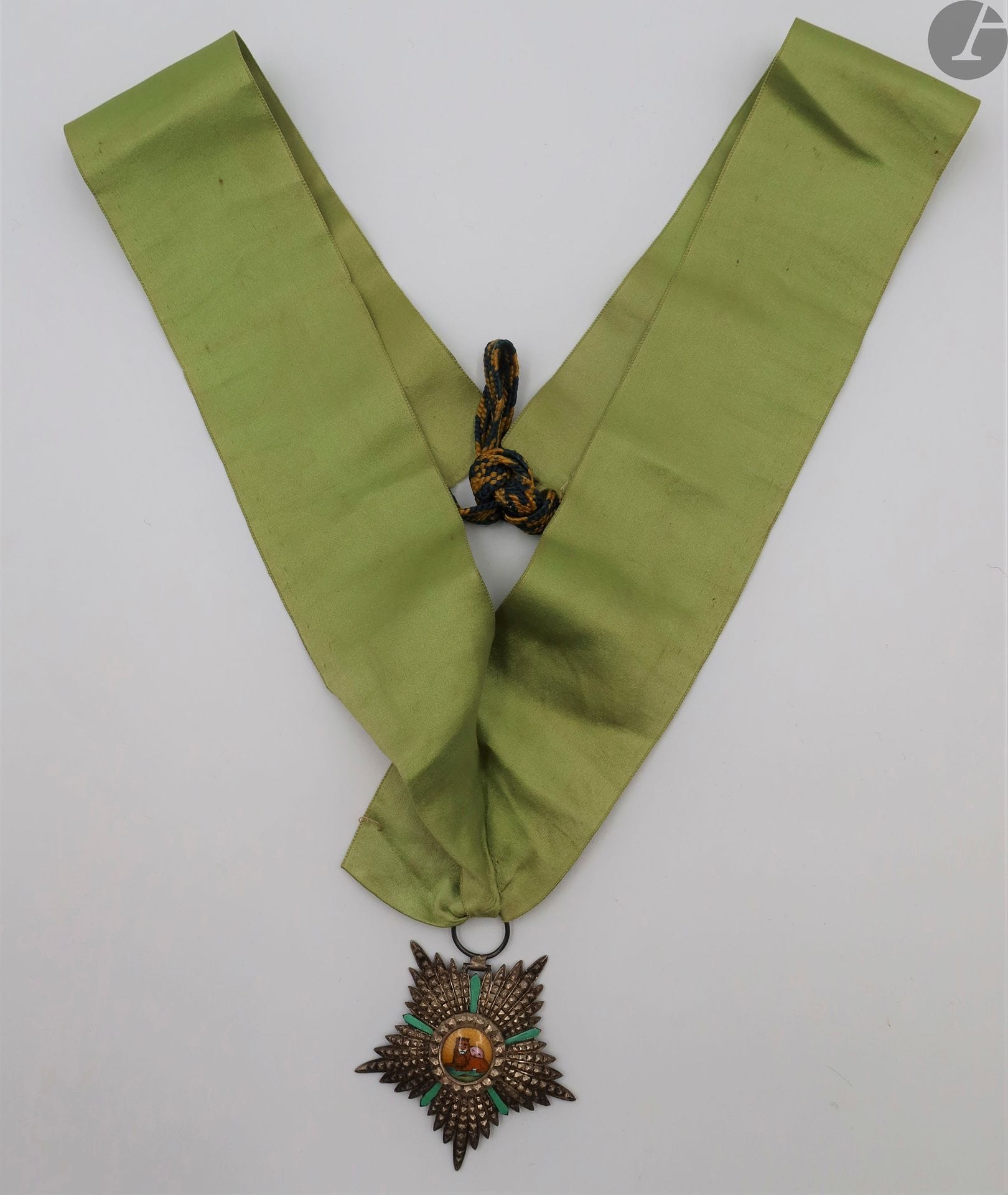 PERSE 
ORDRE DU LION ET DU SOLEIL, créé en 1807. 
Étoile de chevalier modifiée en commandeur. 
En argent et émail (émail des rayons refaits). Monté avec une longue cravate en soie verte fermant par deux lacets en passementerie. 
62 mm - Poids brut : 22 g
B.