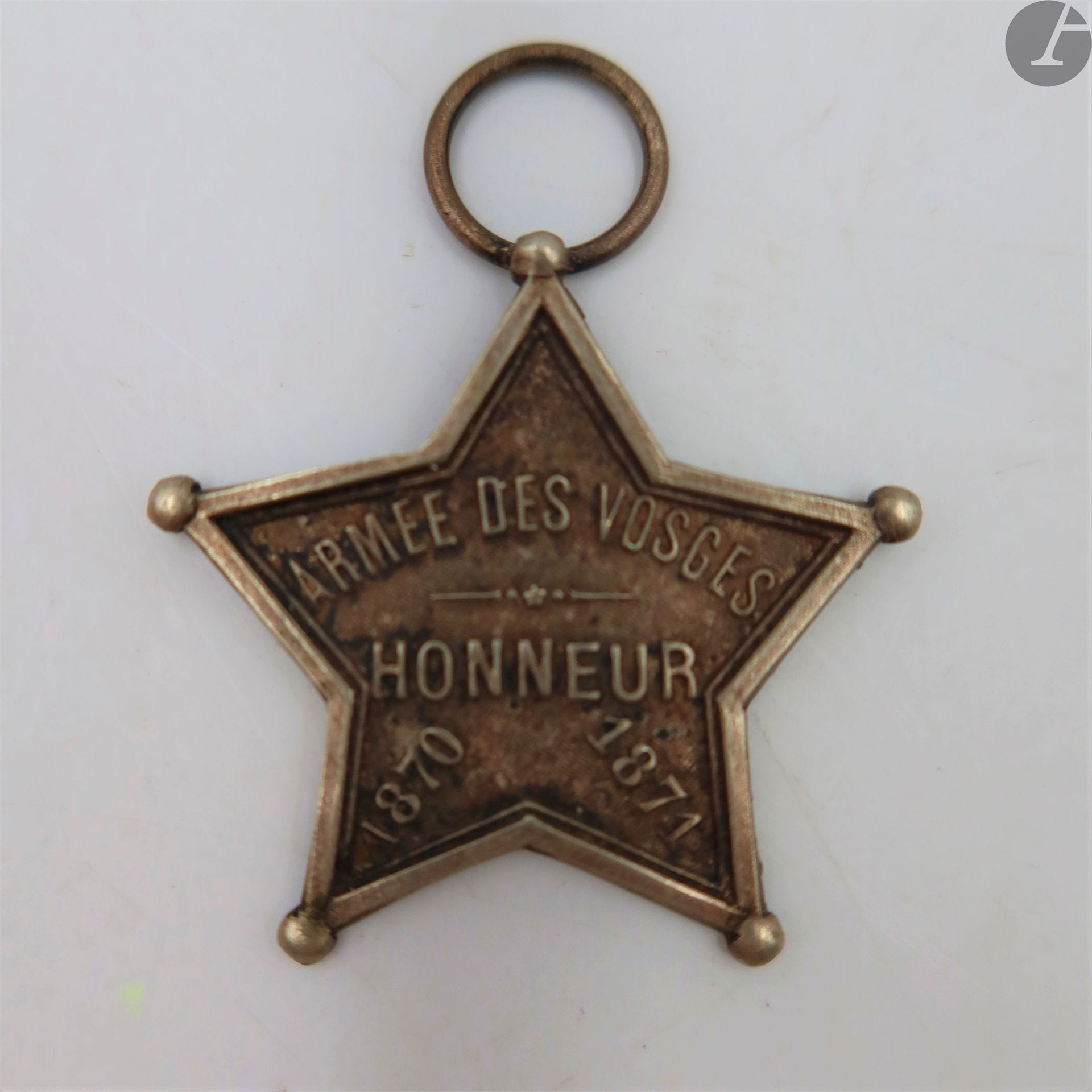 FRANCE 
INSIGNE COMMÉMORATIF DE L’ARMÉE DES VOSGES (1870-1871)
En métal argenté estampé, à anneau fixe. Marqué « ARMÉE DES VOSGES – HONNEUR – 1870-1871 »
35 mm
T.T.B.
