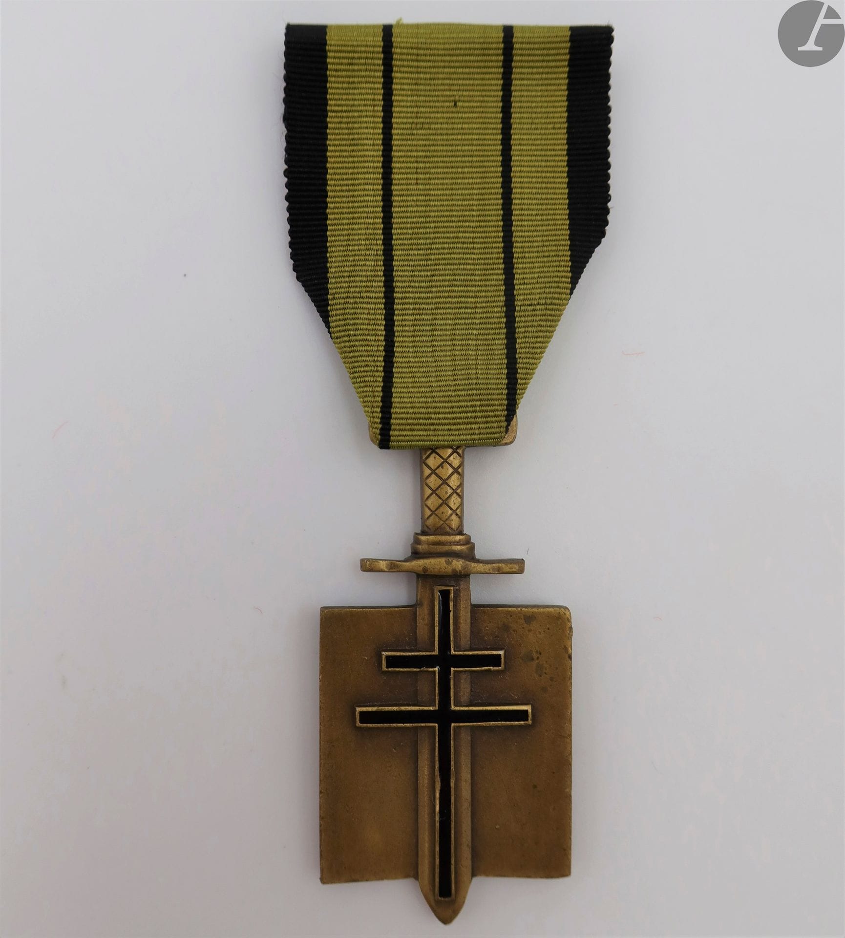 FRANCE 
ORDRE DE LA LIBÉRATION 
Croix de compagnon. 
En bronze. Poignée du glaive striées sur l’avant et le revers. Croix émaillée noire. Sans poinçon. 
Ruban du 2e type (légèrement insolé). 
59 x 29 mm
T.T.B.
