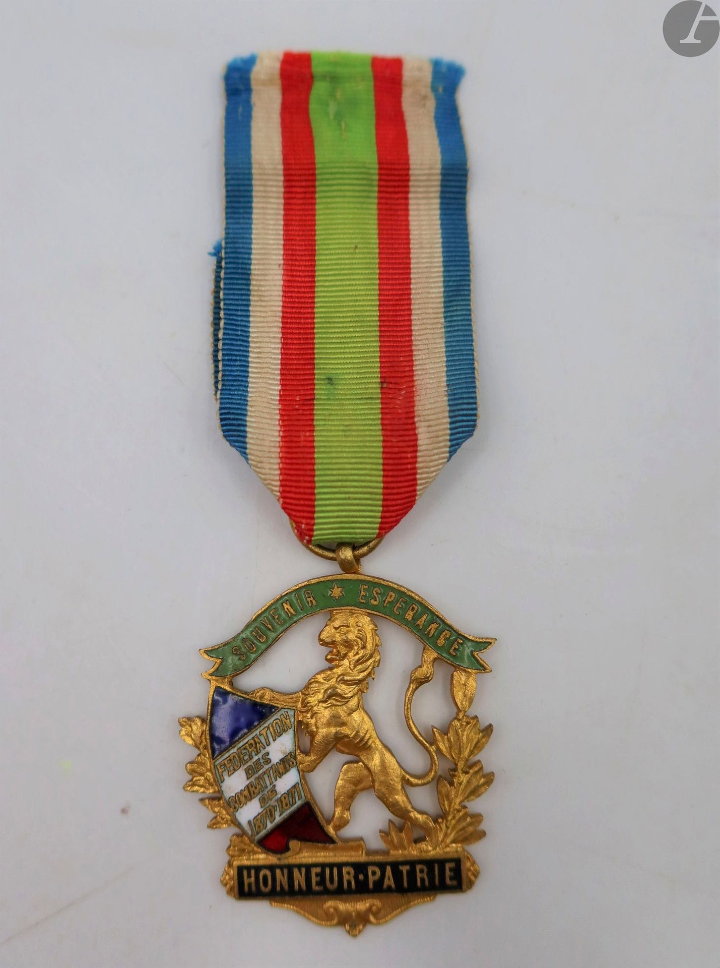FRANCE 
INSIGNE DE MEMBRE DE LA FÉDÉRATION DES COMBATTANTS (1870-1871).
En laiton doré et émaillé, uniface. Ruban ancien. 
44 x 38 mm
T.T.B.