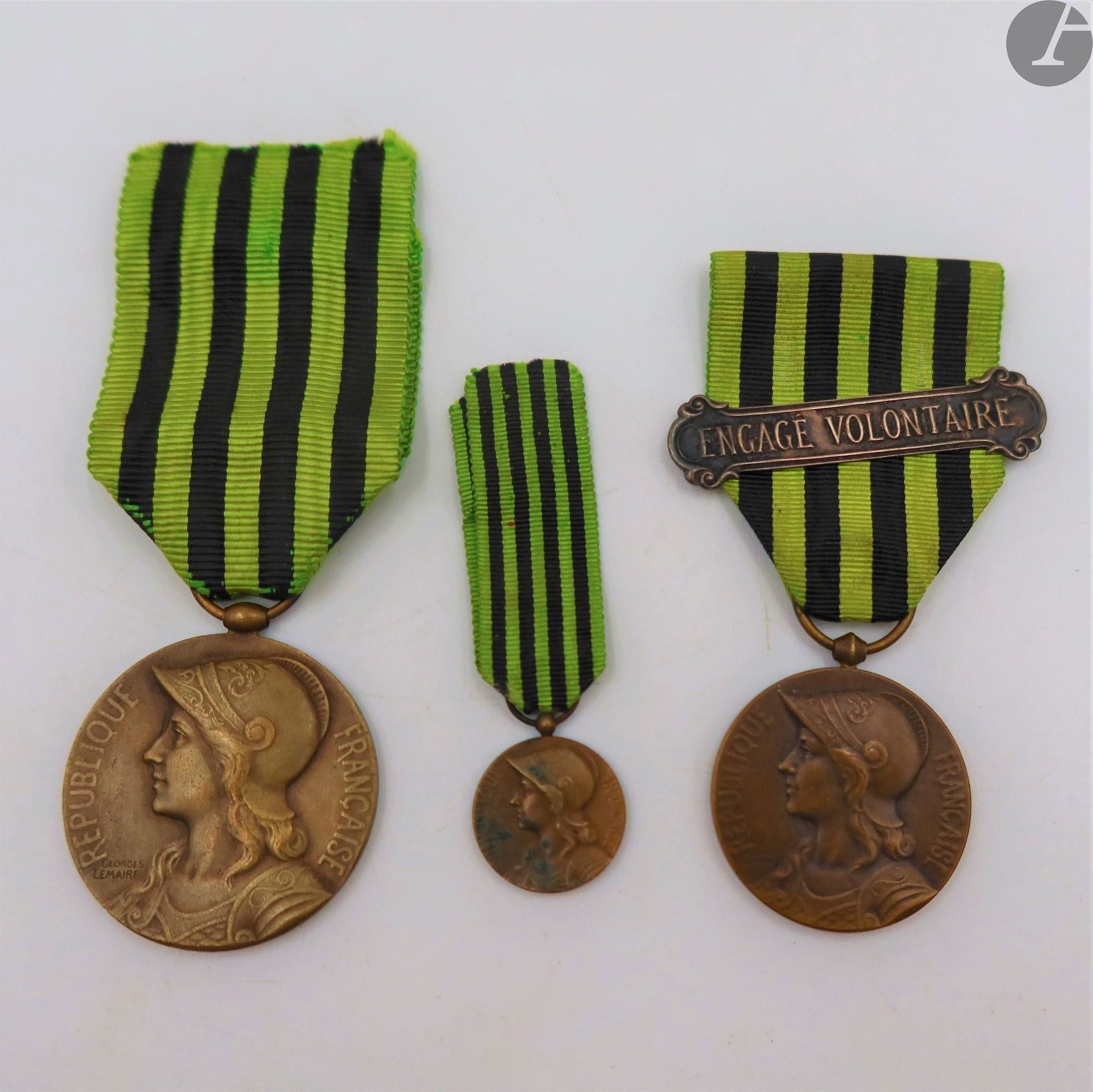 FRANCE 
MÉDAILLE COMMÉMORATIVE DE LA GUERRE DE 1870. 
Trois médailles en bronze : 
- une de gros module. Ruban. 36 mm
- une de petit module. 28 mm. Ruban à agrafe « engagé volontaire »
- une réduction. Ruban. 15 mm
T.T.B.