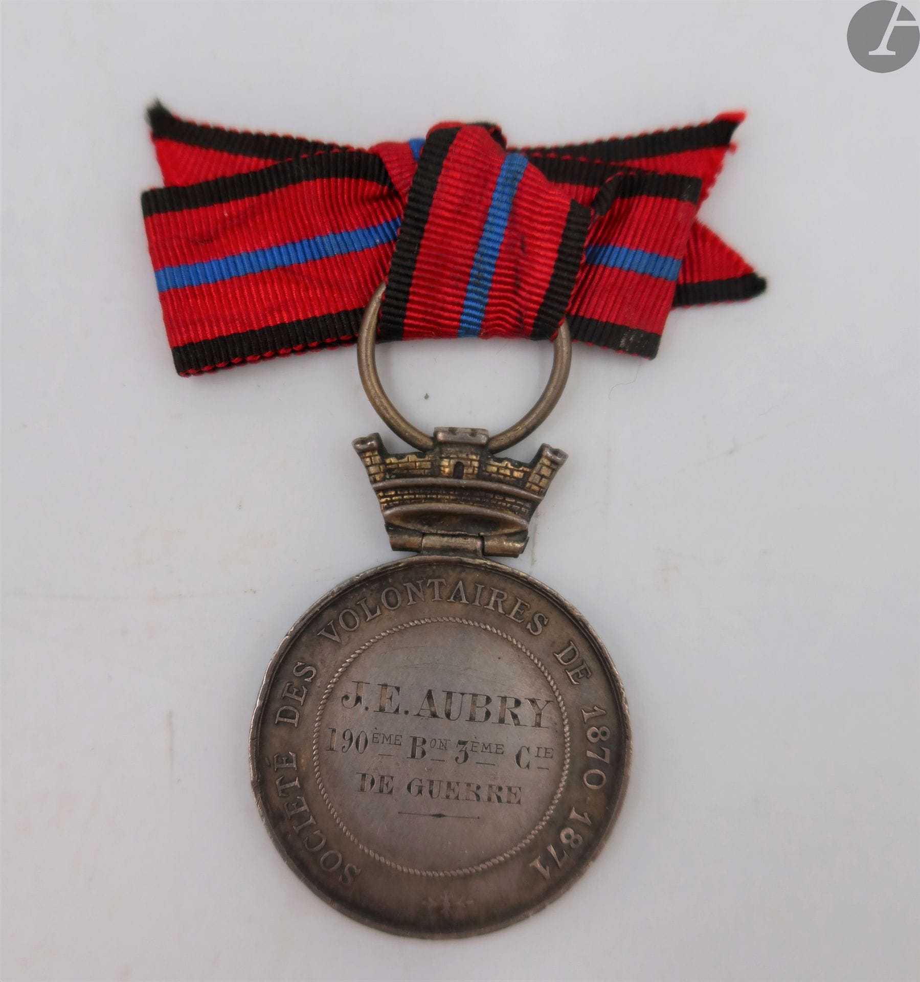 FRANCE 
MÉDAILLE DE LA SOCIÉTÉ DES VOLONTAIRES 1870-1871
Médaille de la Société des Volontaires 1870-1871 dite « à la branche de houx » du 1er type en argent. 
Attribuée au revers « J.E. AUBRY 190E BON 3E CIE DE GUERRE » Couronne montée à charnière. Poinçon « ARGENT » de la Monnaie de Paris sur la tranche. 
Ruban ancien monté en nœud de boutonnière
37 x 27 mm - Poids net : 12 g
T.T.B.