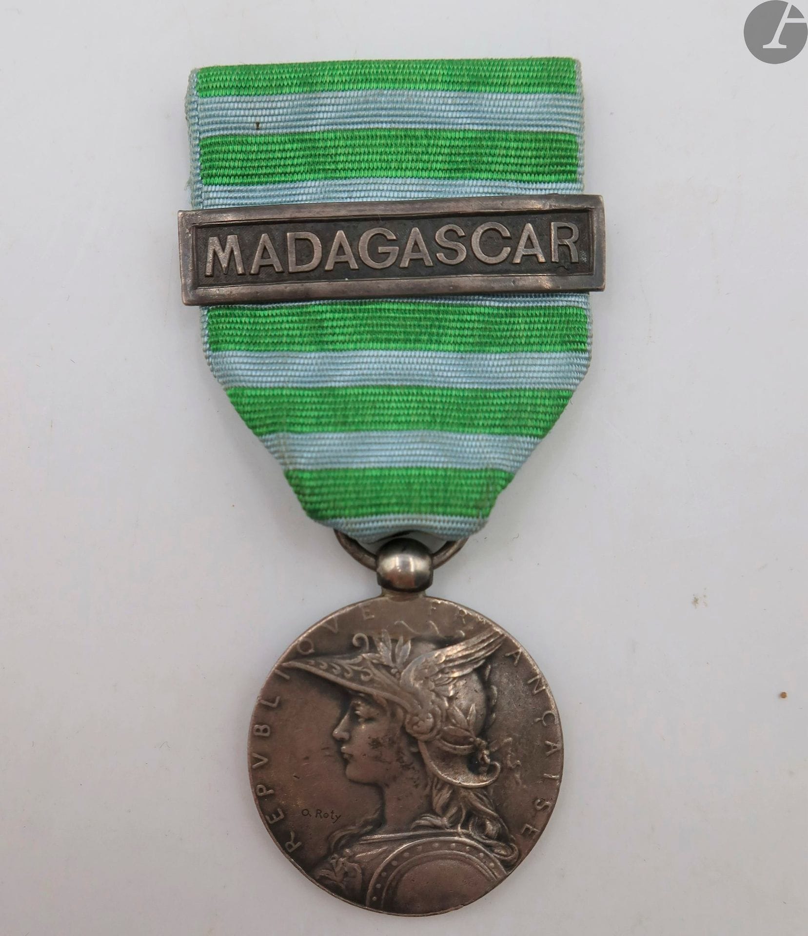 FRANCE 
MÉDAILLE DE MADAGASCAR (1895) 
Médaille par Roty. En argent. Bélière olive. Poinçon de la Monnaie sur la tranche. Ruban avec une agrafe de médaille coloniale « Madagascar » en argent. 
28 mm - Poids brut : 18 g
T.T.B.