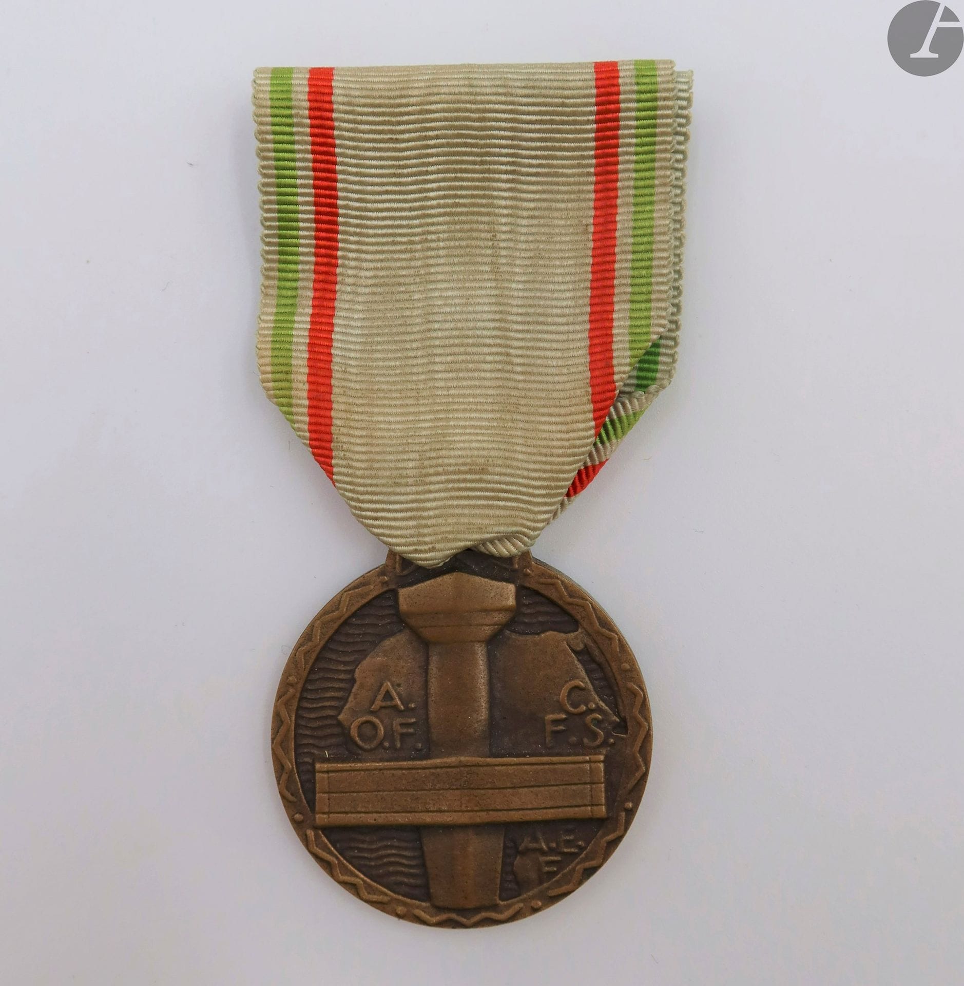 FRANCE 
MÉDAILLE DU MÉRITE DE L’AFRIQUE NOIRE FRANÇAISE. 
En bronze, non poinçonnée. Ruban ancien (légèrement insolé). 
34 mm
T.T.B. à SUP.