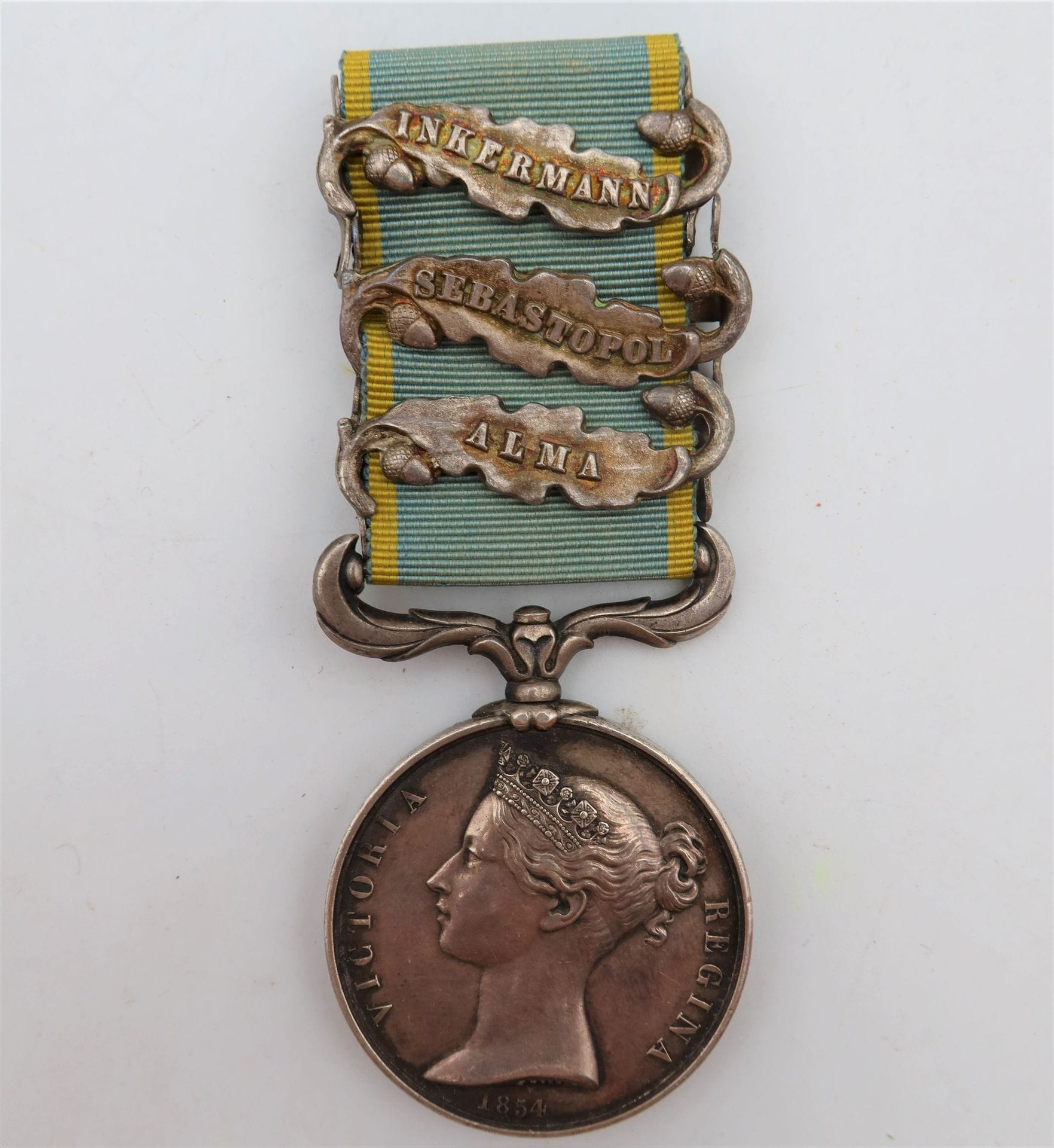 GRANDE-BRETAGNE 
MÉDAILLE DE CRIMÉE (1856) 
Médaille par Wyon, en argent. Ruban à trois agrafes anglaises indépendantes « Inkermann », « sebastopol » et « alma ». 
34 mm - Poids brut : 40 g
T.T.B.