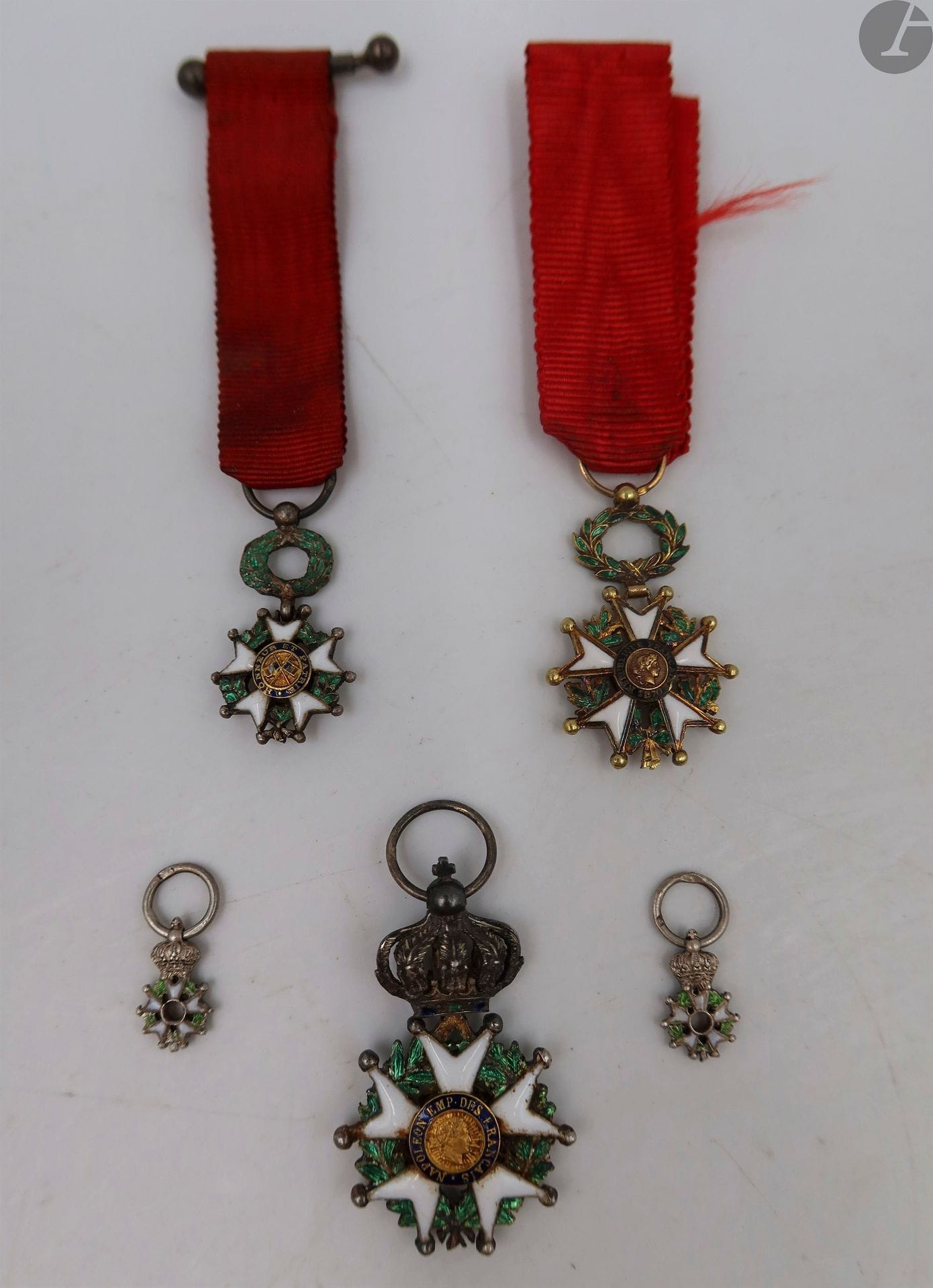 FRANCE 
ORDRE DE LA LÉGION D’HONNEUR, institué en 1802. 
Trois miniatures et deux réductions : 
- deux miniatures Second Empire. En argent (manque les centres). Hauteur : 9 mm
- une réduction d’une étoile de chevalier Second Empire. Argent, or et émail (infimes éclats). 27 x 15 mm
Poids : 2,9 g
- une réduction d’une étoile d’officier IIIe République, modèle à filets. Or et émail. Poinçon tête d’aigle. Ruban de chevalier.
21 x 15 mm - Poids brut : 2,6 g
Petit éclat au centre
- une miniature de chevalier IIIe République. 
T.T.B.