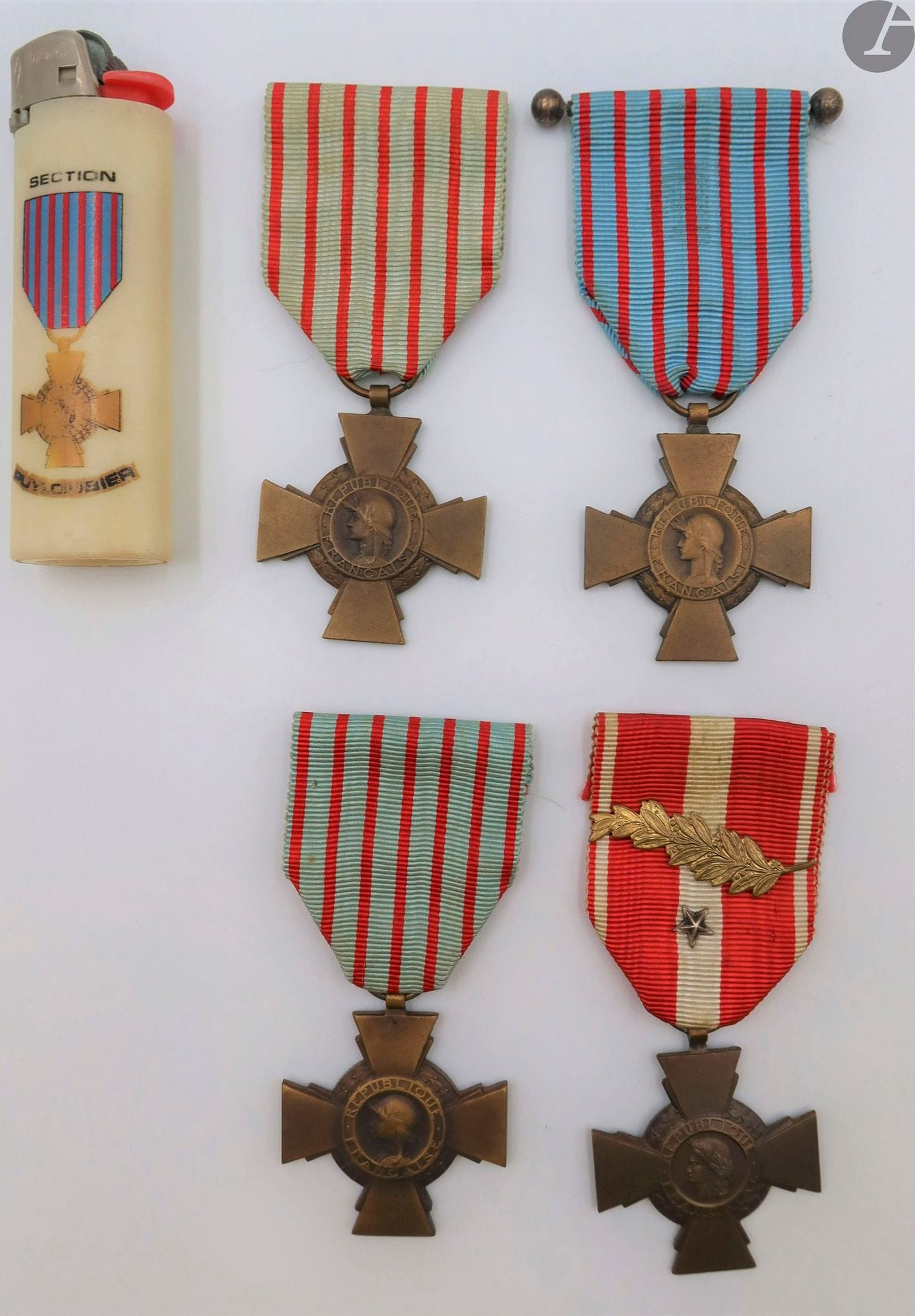 FRANCE 
CROIX DU COMBATTANT (1930) – croix de la valeur militaire (1956) 
Quatre croix : 
- croix de la valeur militaire. En bronze. Fabrication de la Monnaie. Ruban à une palme d’or et une étoile d’argent. 
- deux croix du combattant. En bronze. Poinçons de fabricants (différents). 
- croix du combattant « 1939-1940 ». En bronze. Ruban du modèle standard. Fabrication de la Monnaie. Rubans. 
- brevet de la croix du combattant de l’union départementale des groupements de l’Ain. Au nom de Marius MOREL des 4e et 5e RIC. Présenté encadré sous verre avec croix du combattant.
On y joint un briquet à la croix du combattant