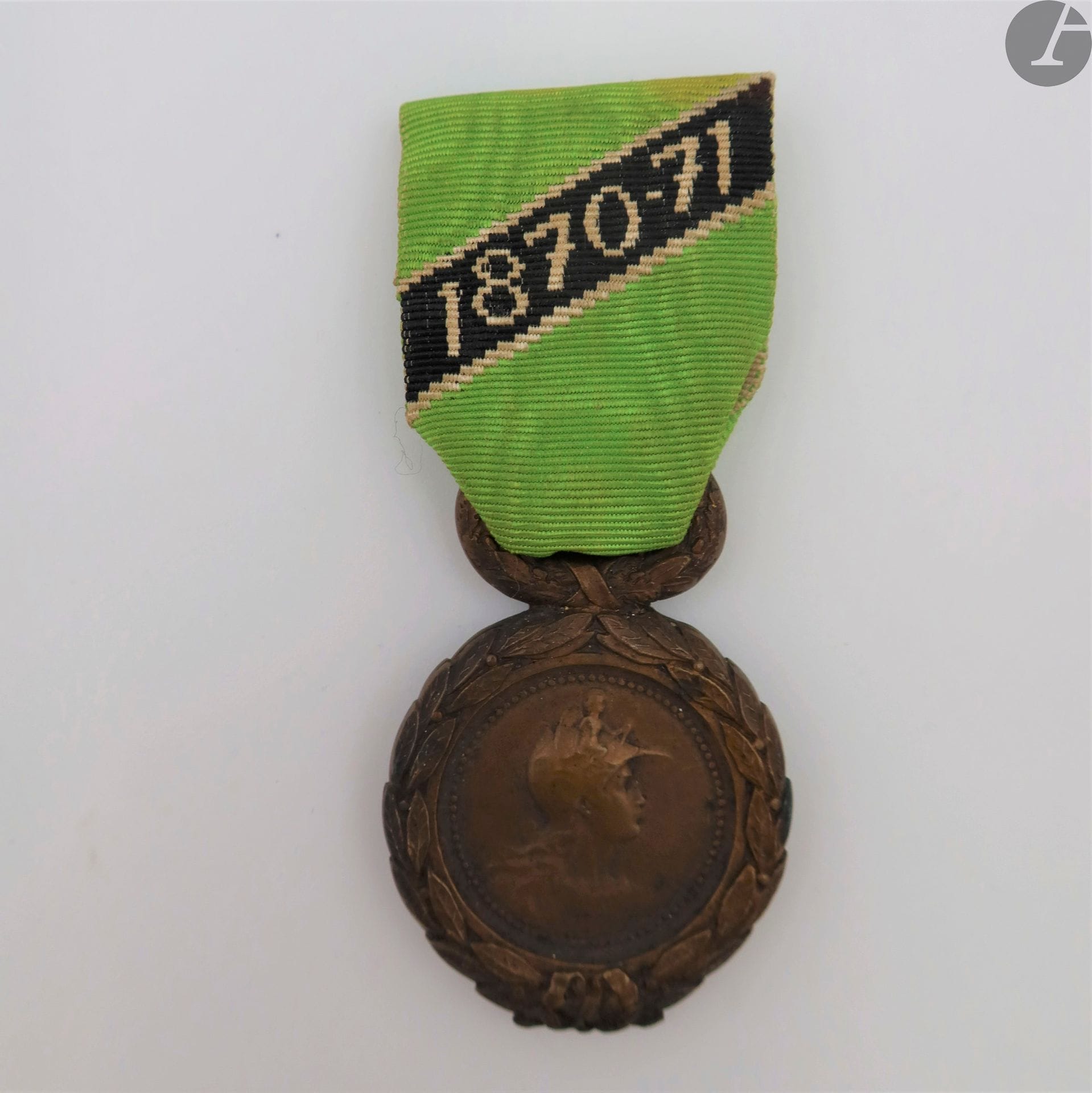 FRANCE 
INSIGNE DE MEMBRE DE LA SOCIÉTÉ DES ENGAGÉS VOLONTAIRES MINEURS DE 1870-1871. 
En bronze patiné. Ruban brodé du 1er modèle, cousu, avec bouton d’attache de Duseaux. 
47 x 31 mm
T.T.B.