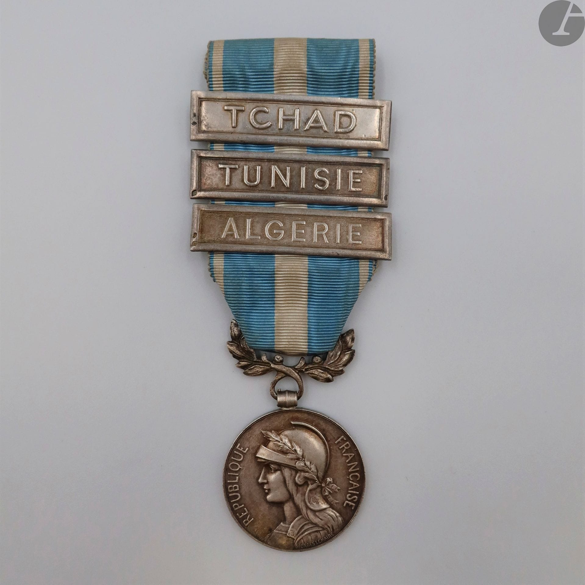FRANCE
MÉDAILLE COLONIALE (1893)
Médaille coloniale du 1er type, par Lemaire.
En argent. Jeton poinçonné de la Monnaie de Paris. Bélière biface poinçonné tête de sanglier et Mercier.
Ruban à trois agrafes à clapets poinçonnées à la tête de sanglier.
Une « Algérie, une « TCHAD » et une « Tunisie », poinçonnées du fabricant Mercier.
Poids brut : 32,9 g
T.T.B.