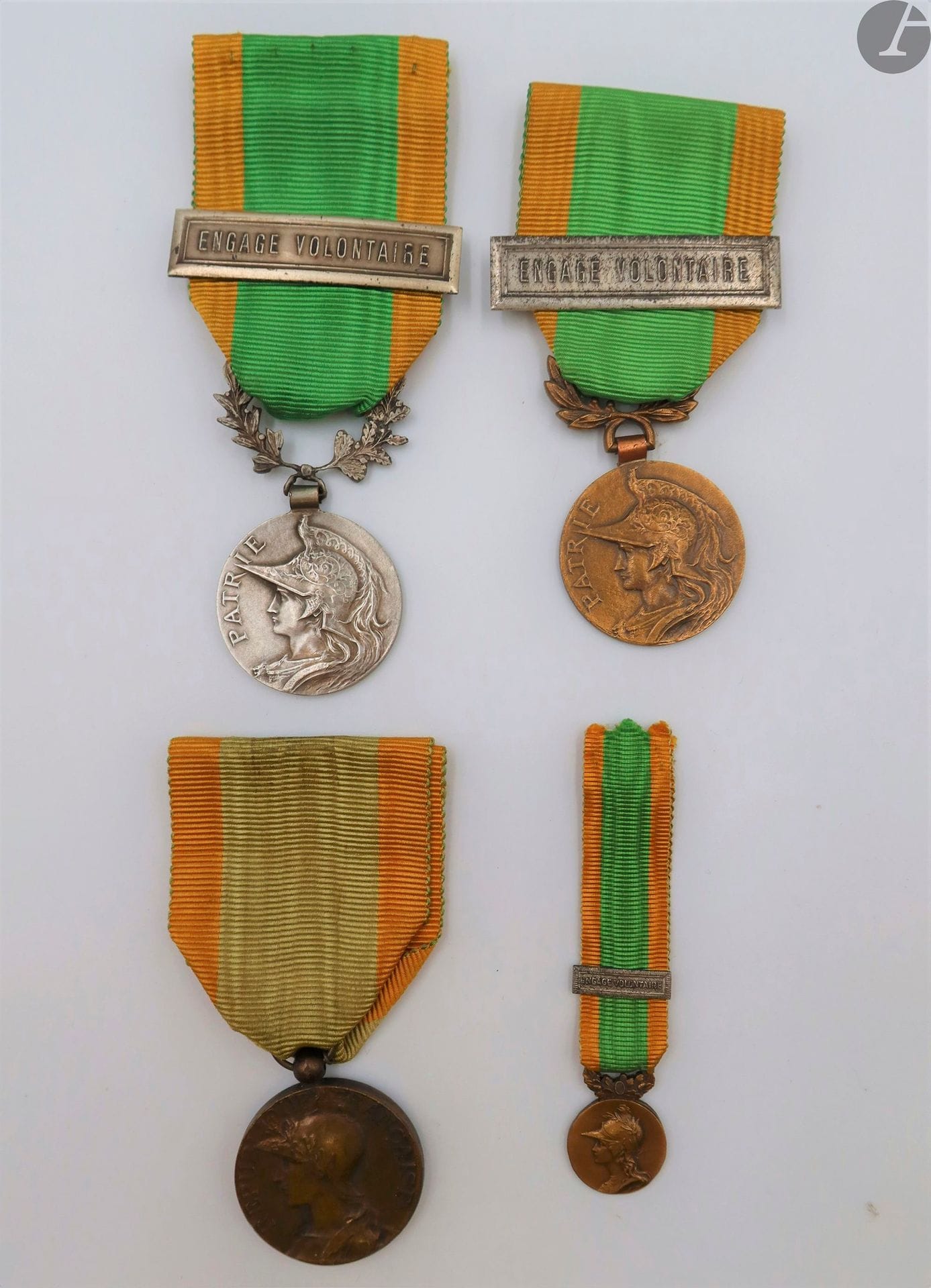 FRANCE 
MÉDAILLE DES ENGAGÉS VOLONTAIRES 
Ensemble de quatre médailles : 
- modèle par RIVET (1870). En bronze. Bélière boule. Ruban.
- modèle à bélière découpée feuilles de laurier. En bronze. Ruban à agrafe argentée « Engage volontaire ».
- modèle à bélière découpée feuilles de de chêne et laurier. En bronze argenté. Ruban à agrafe argentée « Engage volontaire ».
- miniature en bronze. Ruban à agrafe. 
T.T.B. à SUP.
