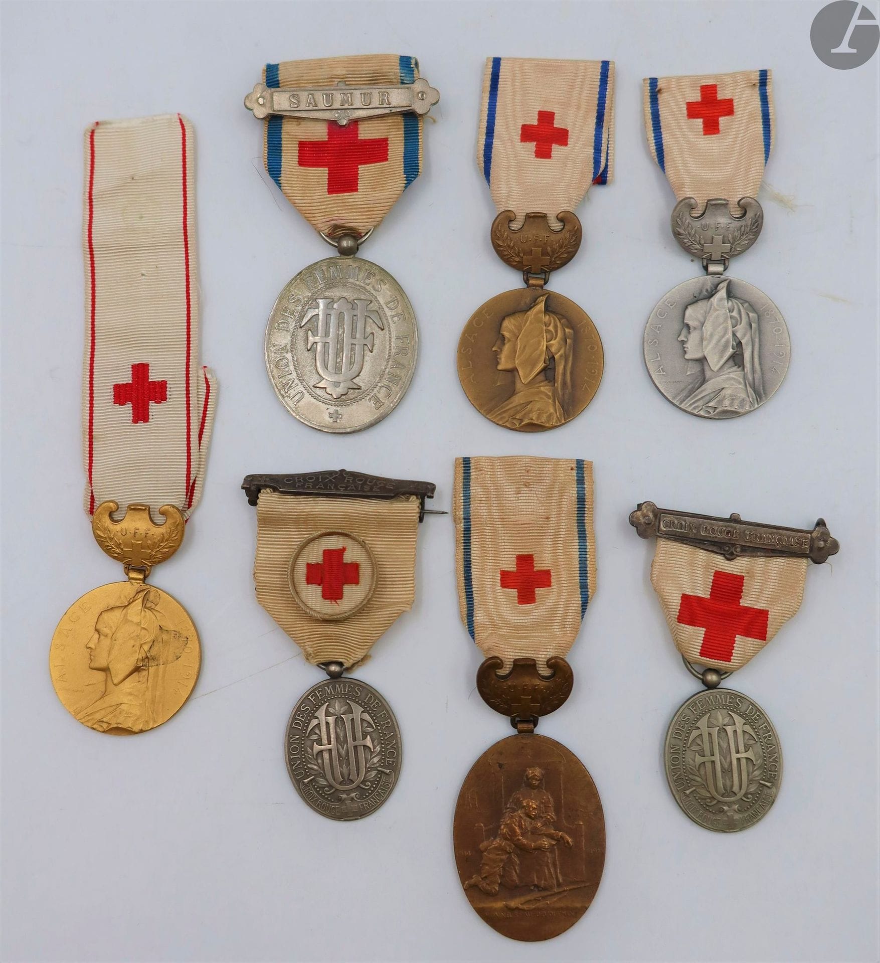 CROIX-ROUGE - UNION DES FEMMES DE FRANCE 
Ensemble de sept médailles et un brevet : 
- une du 1er type, argentée, matriculée « 3211 ». Ruban à agrafe « Saumur ». 
- deux du 2e type, argentées, matriculées « 6787 » et « 23326 ». Rubans à agrafes « Croix rouge française » (deux modèles). 
- trois modèles pour l’administration de l’Union, des trois grades « bronze », « argent » et or ». Rubans (un non au modèle). 
- un modèle pour infirmière, grade « bronze ». Ruban avec étiquette à la plume « Madame la Générale Jacquin ».
- diplôme d’infirmière ambulancière de l’UFF au nom de M Milot. Fait à Paris le 17 avril 1889. Encadré sous verre. 37 x 52 cm
T.T.B.

 Elisabeth Antoine DURENNE (née en 1858), épouse du général Paul Adolphe JACQUIN (1847-1917).
