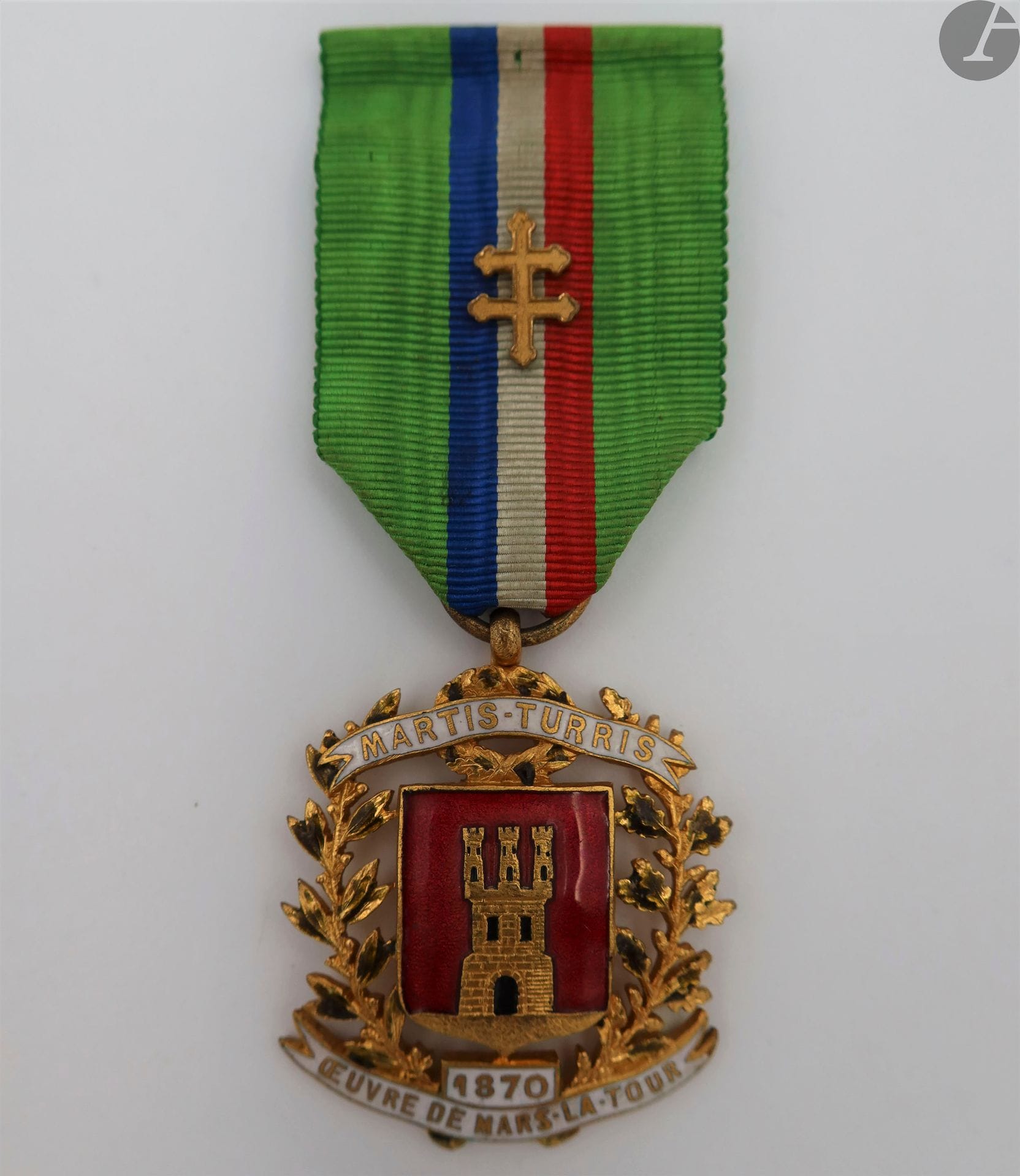 FRANCEBadge
of member of the work of Mars la Tour.
In gilded brass, openwork and enamelled. With the arms of Mars la Tour with two banners " MARTIS TURRIS " and " 1870 ŒUVRE DE MARS LA TOUR ". Stamped on the back " J. CHAUVE(.) "
Ribbon with badge with the cross of Lorraine. 
44 x 33 mmT
.T.B. (Misses to the enamels of the foliages).




