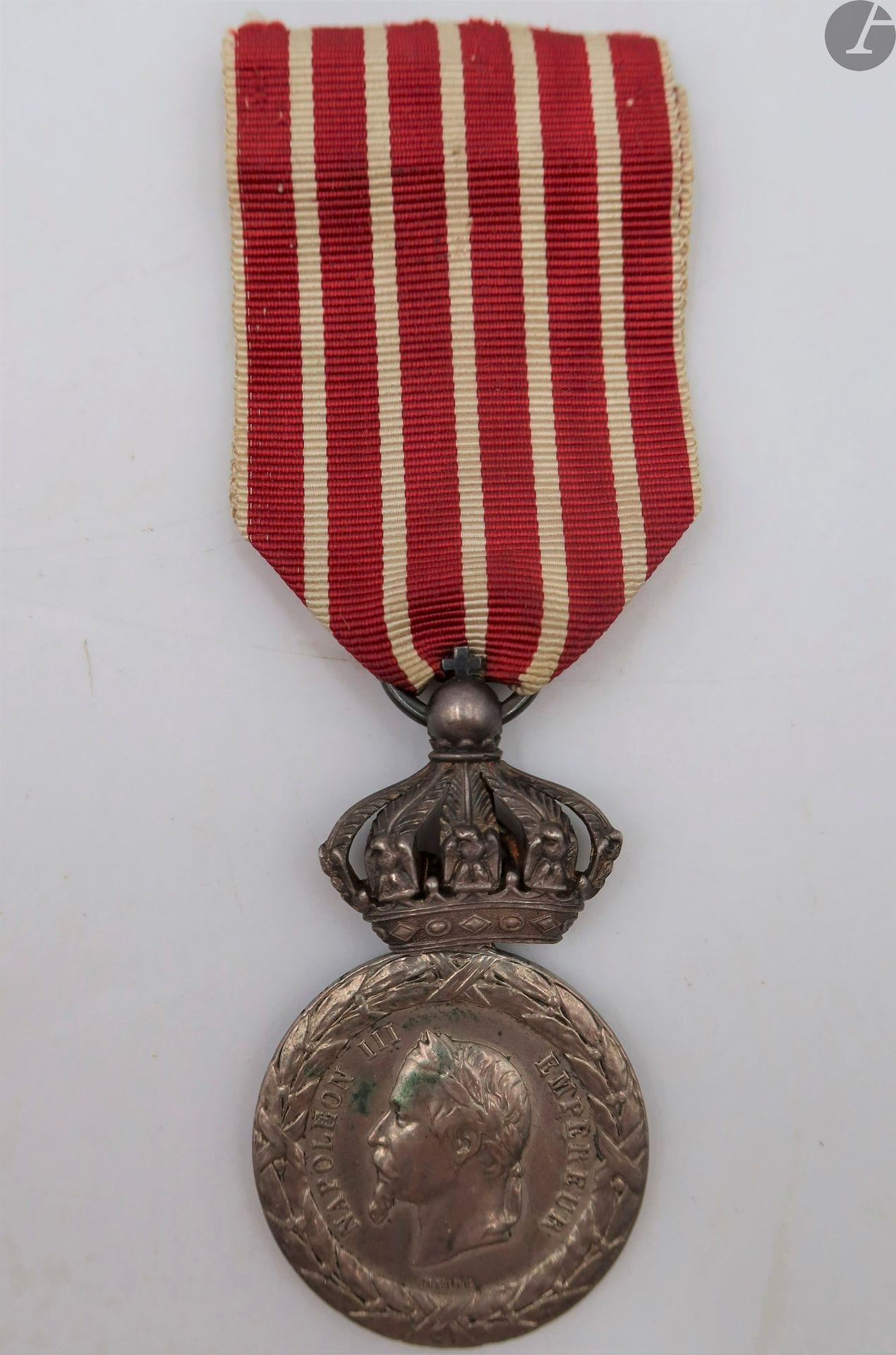 FRANCE 
MÉDAILLE DE LA CAMPAGNE D’ITALIE (1859)
Médaille de la Campagne d’Italie du 2e type, modèle sous couronne, par BARRE, attribuée à un soldat de l’artillerie de la Garde. 
En argent. Ruban. 
Tranche frappée « masson 1743 art m g imp » 
50 x 29 mm - Poids net : 16 g
T.T.B.
