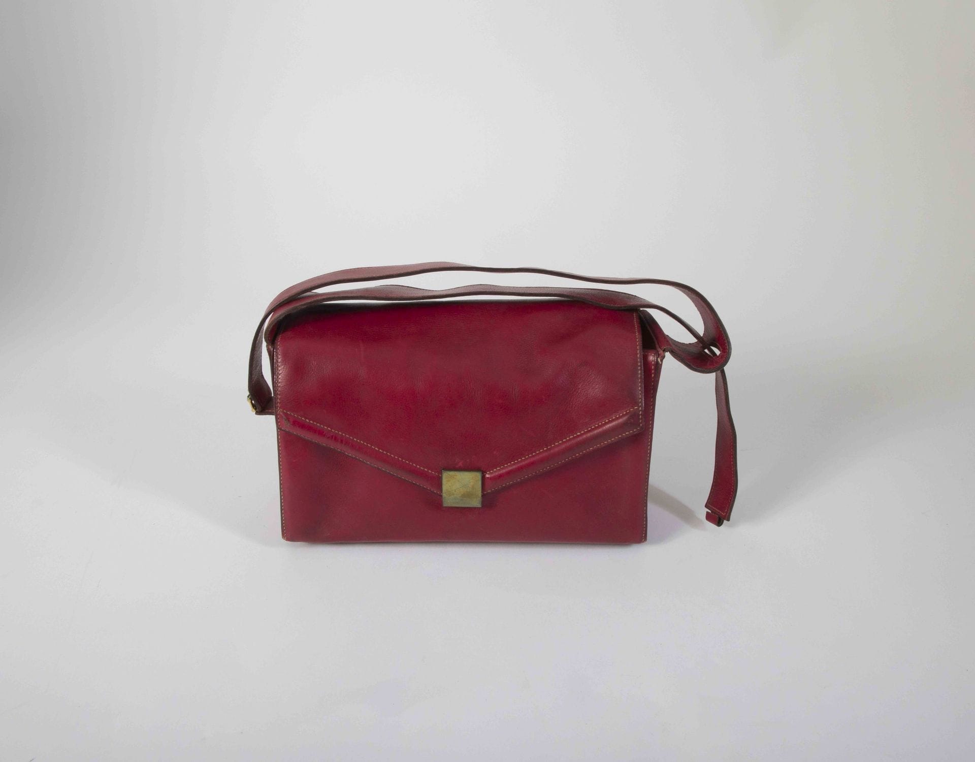 HERMES - PARIS 24.Fg St Honoré Made in France. Circa
1940Deauville"
bag
in red leather, square brass clasp, transformable handle (wear, dirt, accident to a loop of the handle)
26 x 15 x 10 cm

