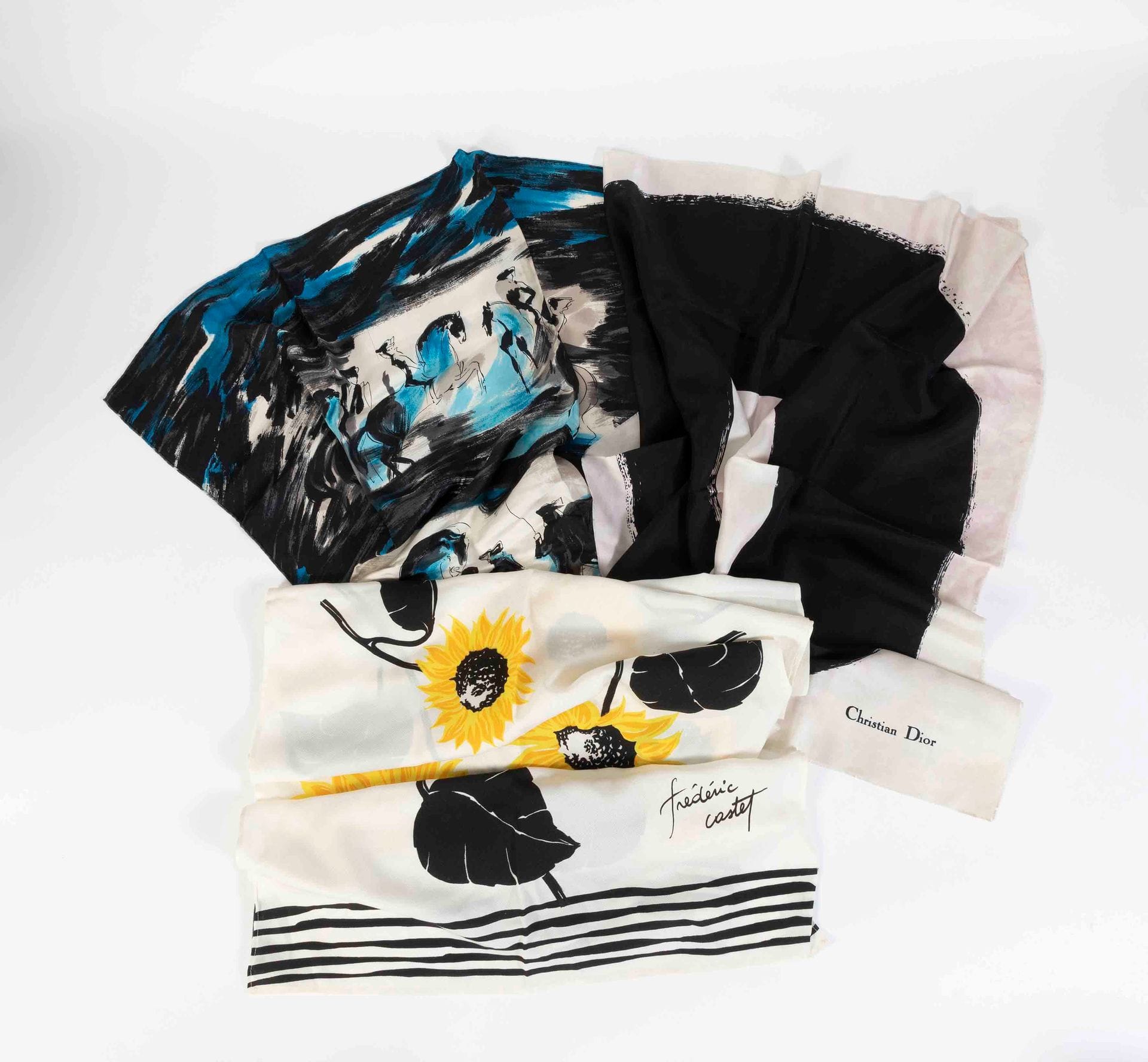Lot de trois foulards, un Christian DIOR noir et blanc (taches et décolorations), un Jeanne Lanvin Castillo et une écharpe Frederic Castet à décor de tournesols
