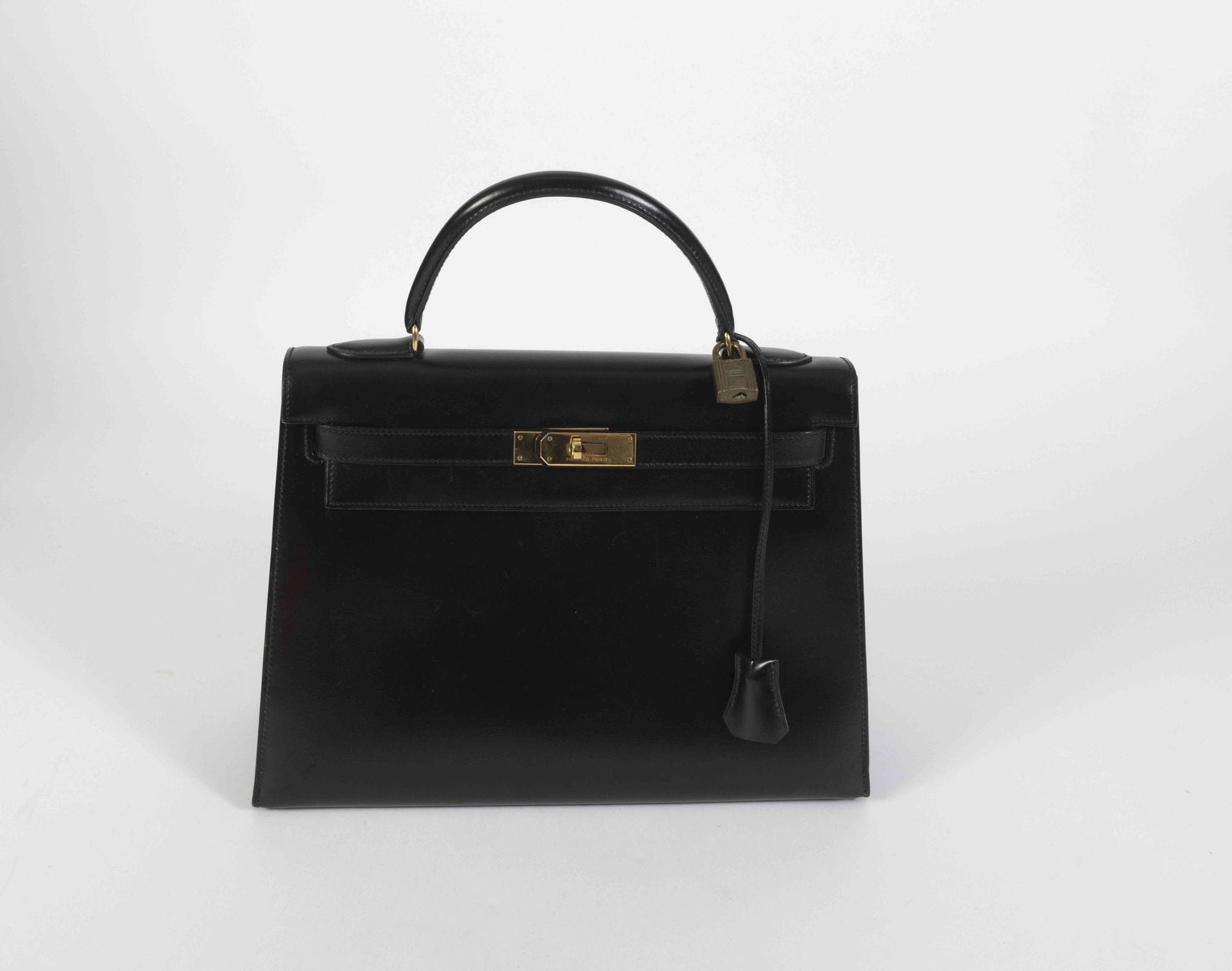 HERMES Paris Made in France. Circa
1987Kelly saddle
bag
32 in black box, gold metal trim, in its cover and box
(some scratches on the back, slight traces)

