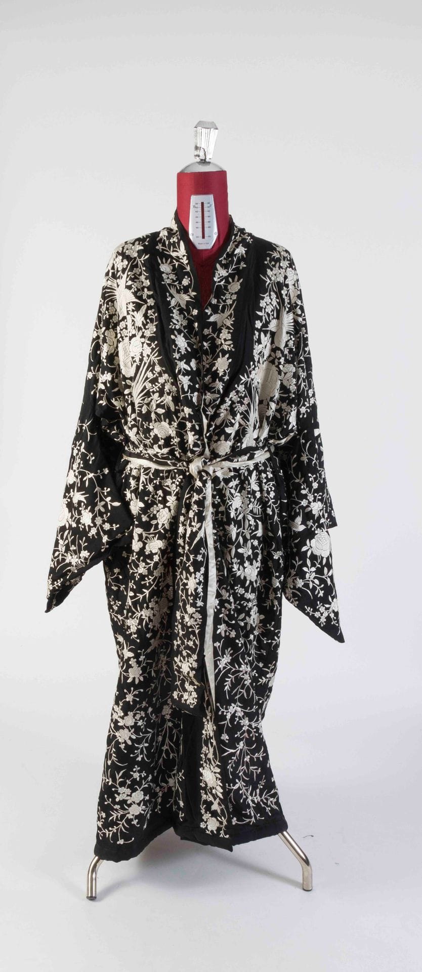 Lot of three Asian pieces including a black silk kimono embroidered with flowers and white birds, a Chinese skirt in cream silk damask, embroidered with blue flowers and polychrome butterflies, a cream silk shawl, polychrome embroidery and gold thread (stains)