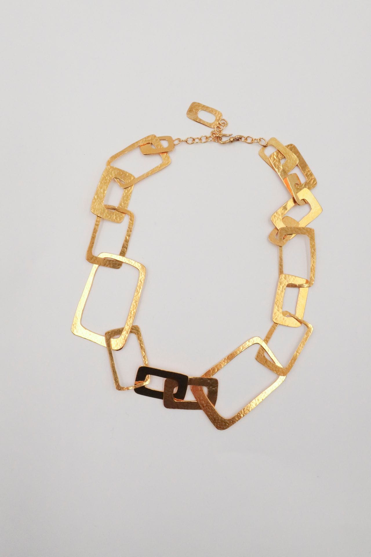 VAN DER STRAETEN
Collier en métal doré en enchevêtrement de rectangles creux de taille aléatoire. Monogrammé. Longueur : 54 cm environ