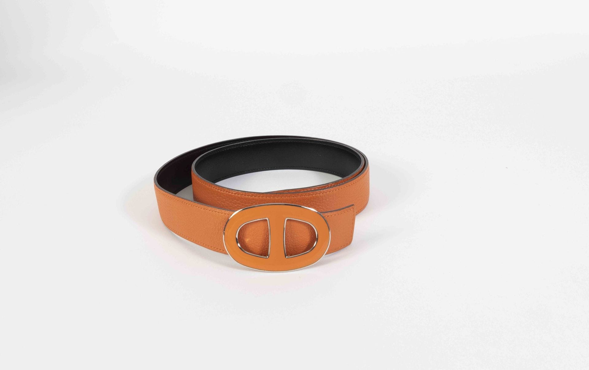 HERMES Paris Made in France. Circa 2010
Ceinture en cuir grainé orange et cuir lisse noir, boucle émaillée orange, T.90