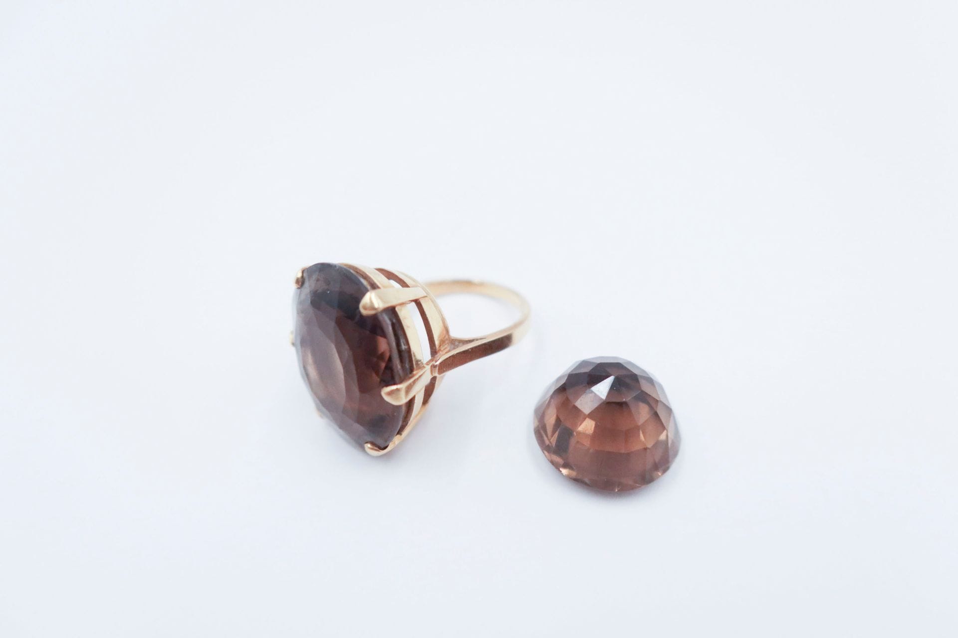 Bague en or 18K (750), ornée d'un important quartz fumé facetté ovale. Tour de doigt : 56. Poids brut : 14,1 g (on joint un quartz fumé facetté rond pesant 21,2 cts ; égrisures)