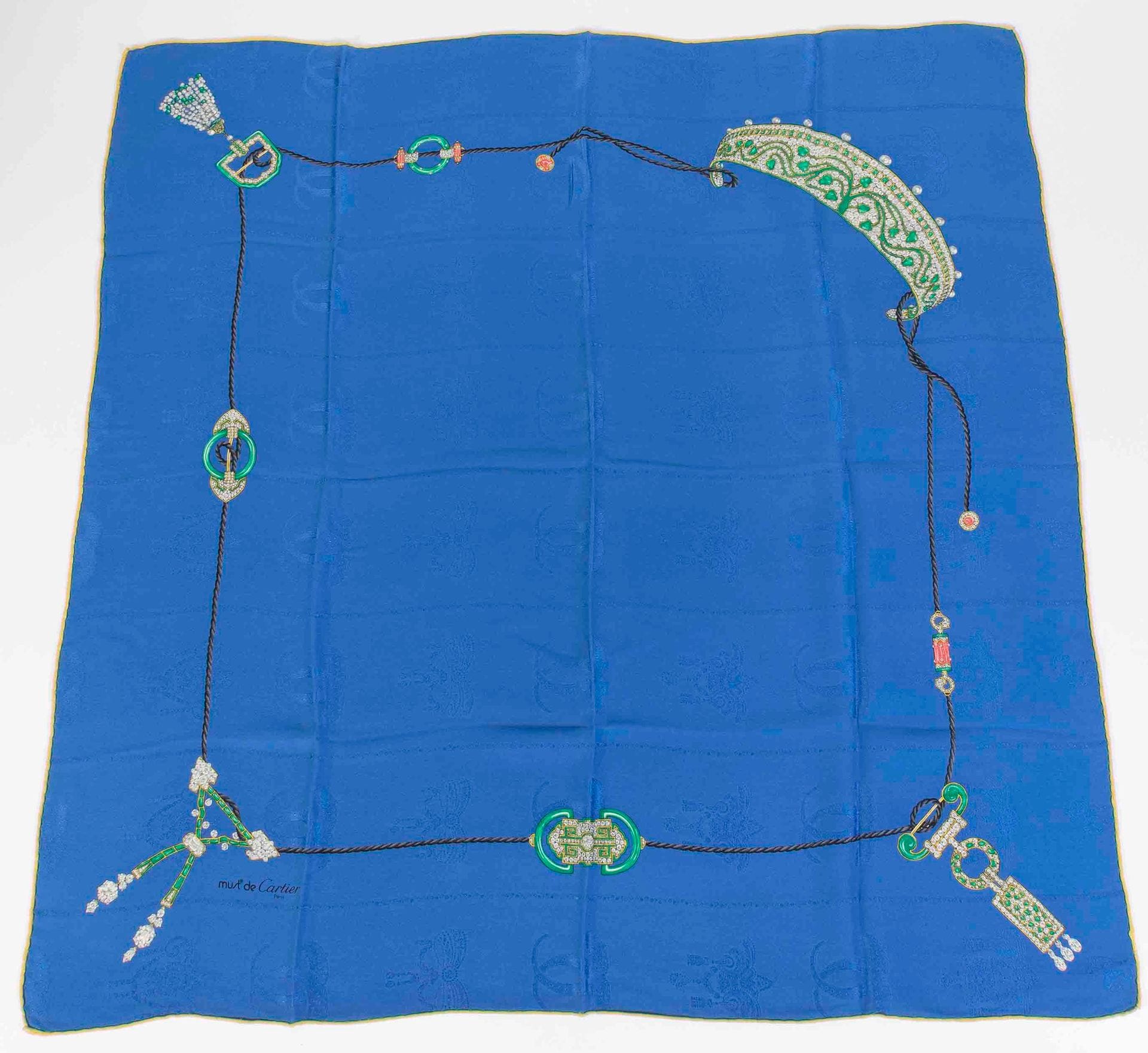 Must de CARTIER
Foulard en soie damassée à décor de bijoux Arts déco, fond bleu, étui cartonné