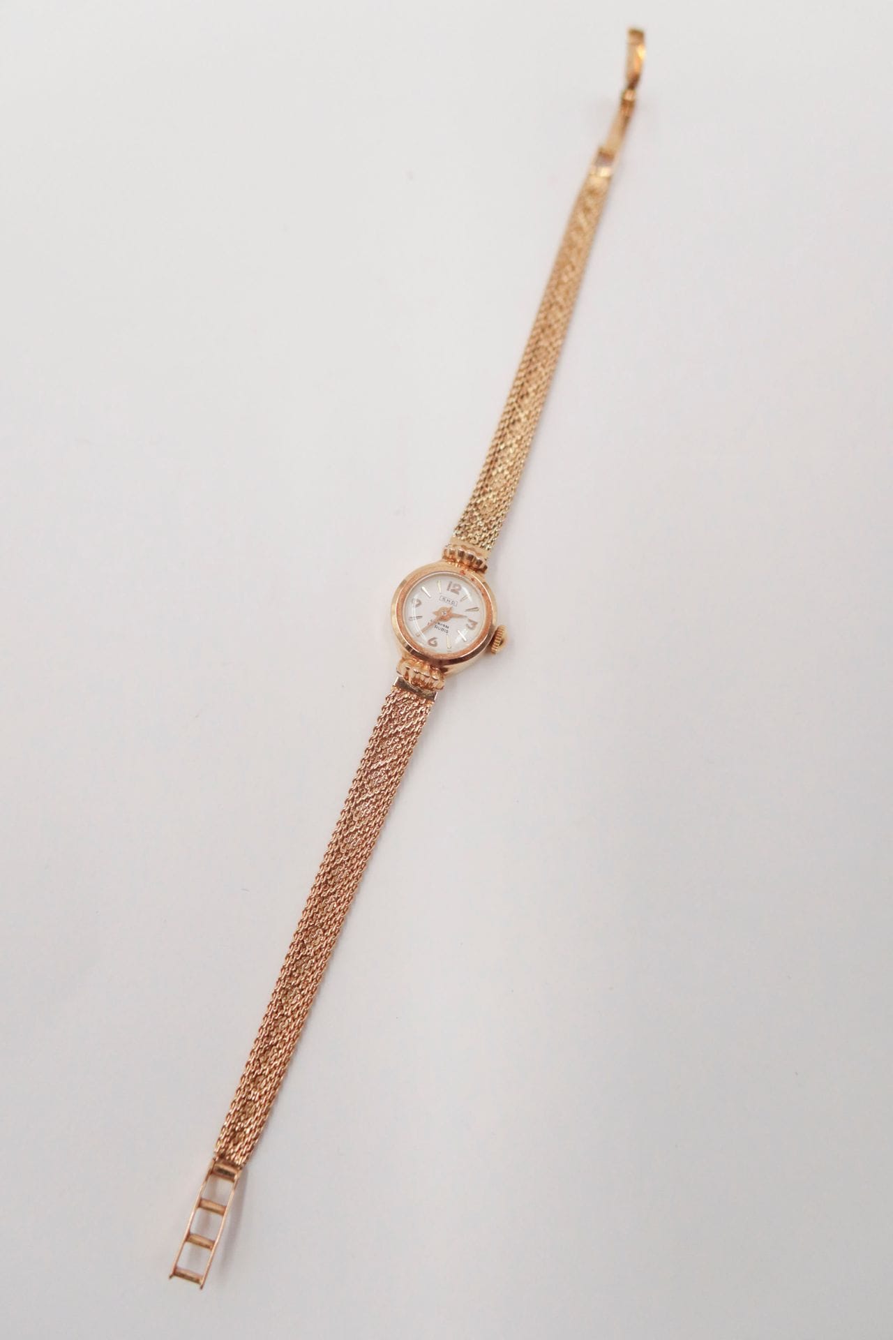 S.H.D
Montre de dame en or 18K (750), cadran rond, bracelet ruban en or 18K, mouvement mécanique. Travail français des années 1950. Longueur : 16,5 cm environ. Poids brut : 12,4 g (mouvement à réviser)