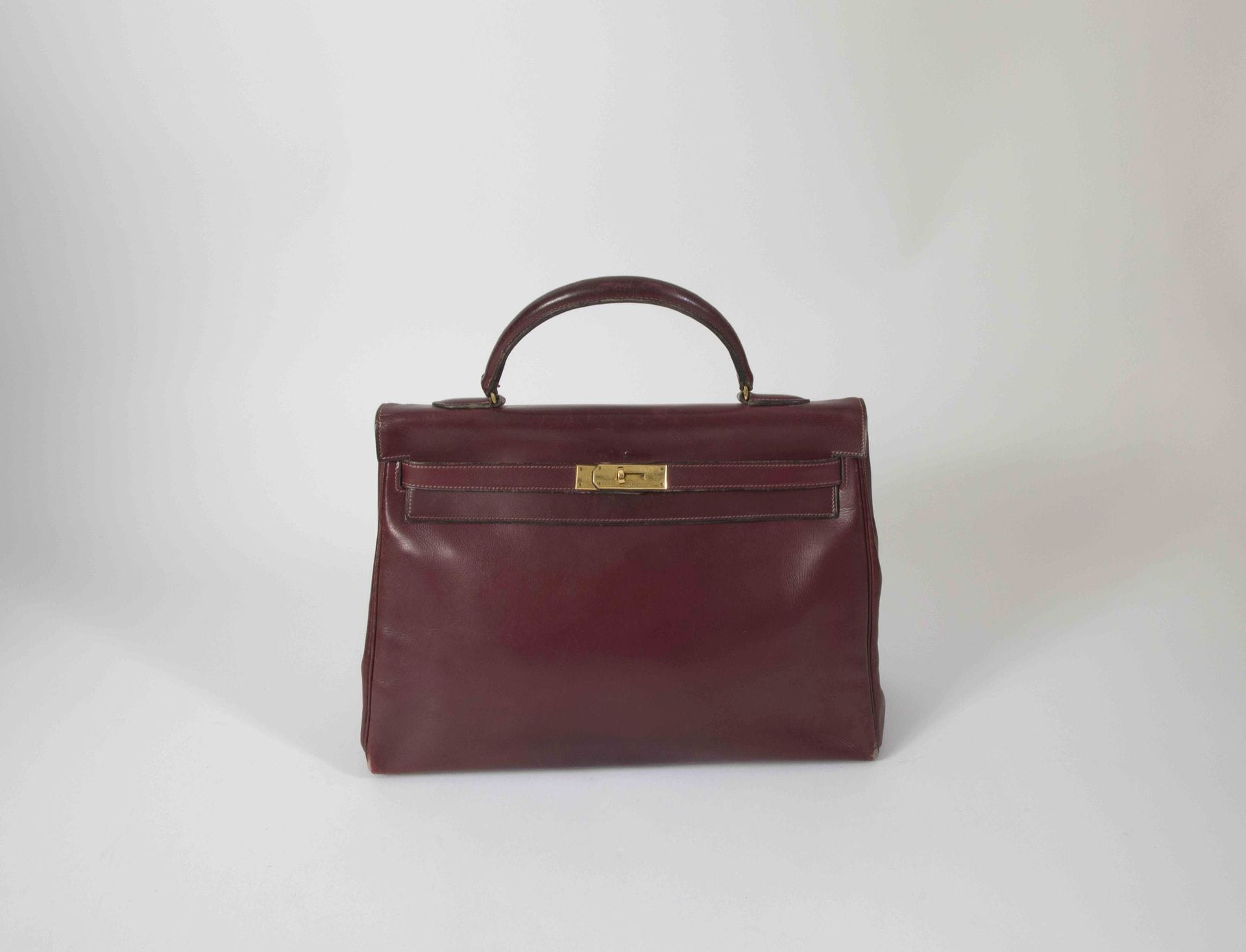 HERMES Paris. Years
1960sBurgundy leather Kelly
bag
35, brass trim (missing padlock, key and bell, worn)
