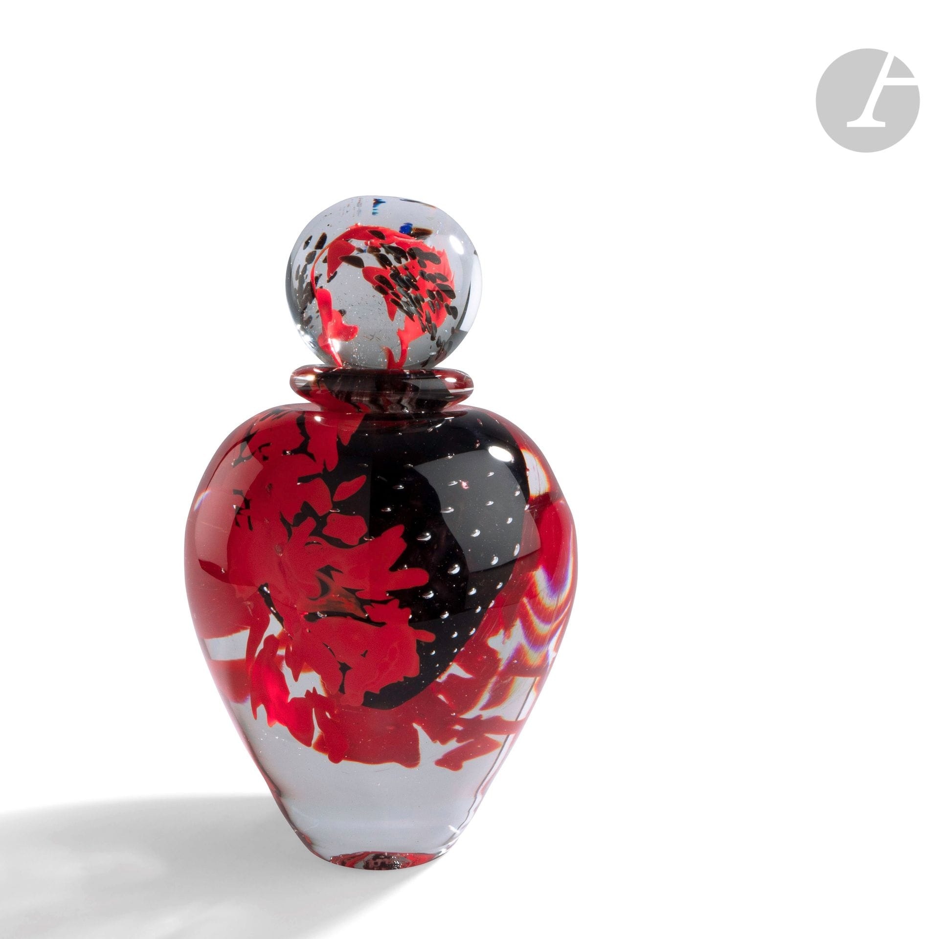 Jean-Claude NOVARO (France, 1943-2014) 
Large blown glass bottle with black oxide decoration, bubbled on comb and covered with red cassons. Signed and dated 24.9.90 under the base. H. 26 cm - D. 17 cmBibliography
: Alain Renner, Novaro Master glassmaker, Edimo Editions, Monaco, 1993
.
