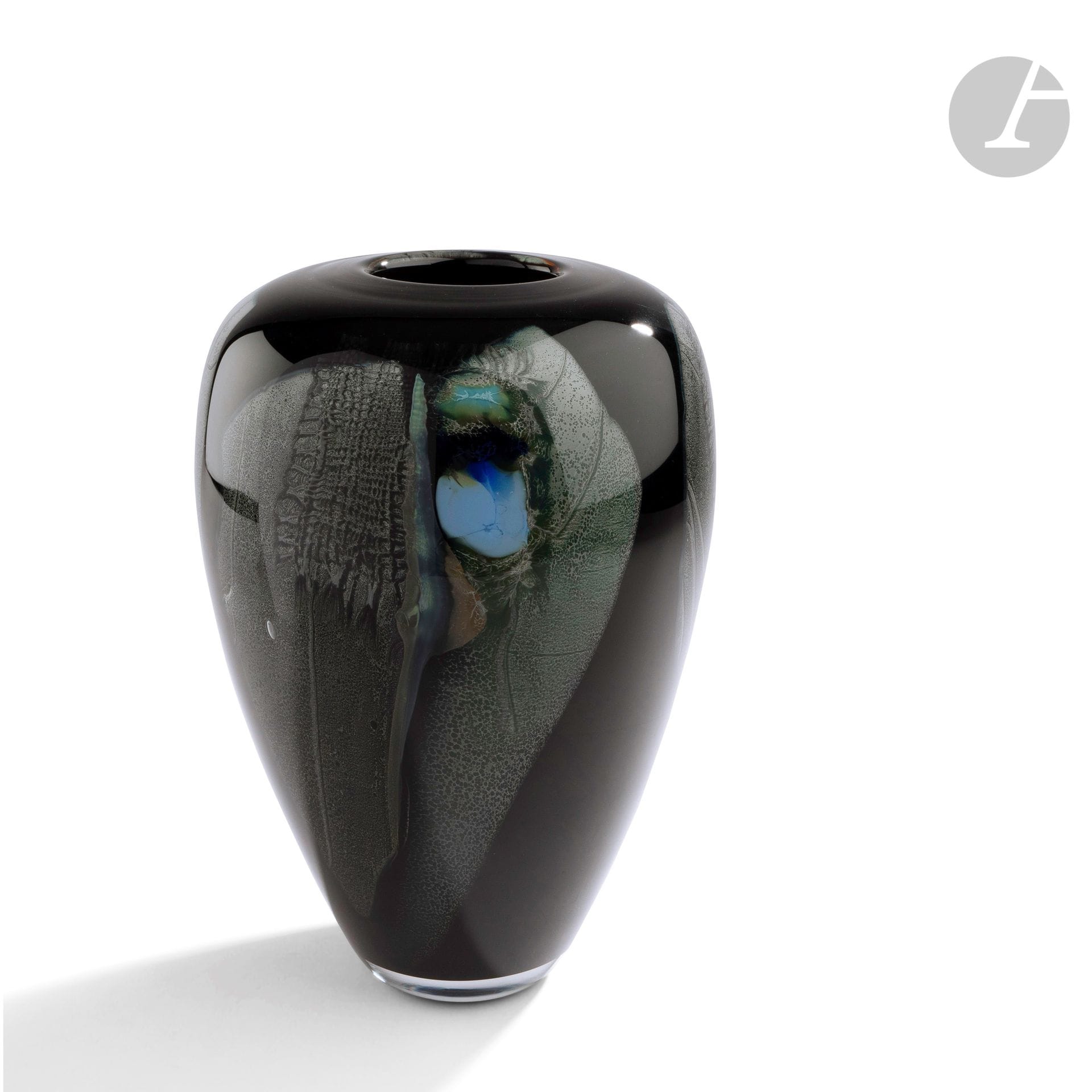 Claude MONOD (France, 1944-1990) 
Blown glass vase, lined with black opaline, decorated on glass plates and fabric, colored with pieces of ballot. Signed, dated 1990 and referenced 90.2.27 under the base. H. 22 cm - D. 16 cm
