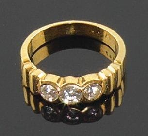 Bague en or jaune, sertie d'une ligne de trois diamants ronds de taille brillant. Tour de doigt: 53 Poids brut: 4 g