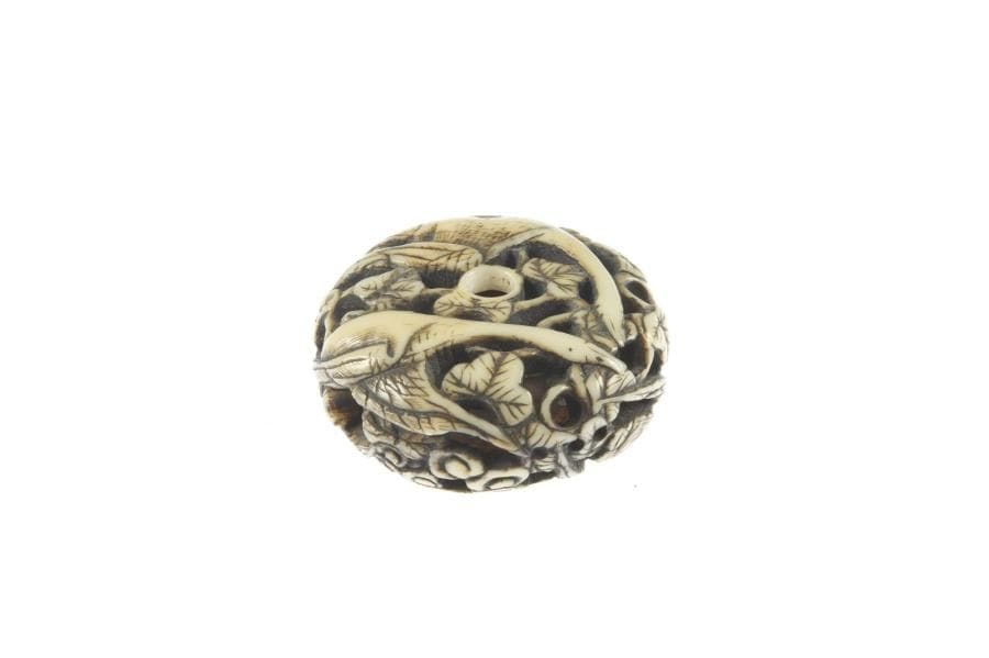 Manju de type ryusa en ivoire à patine jaune à décor sculpté et ajouré d'oies en vol et feuilles au soleil couchant. D. 4 cm.