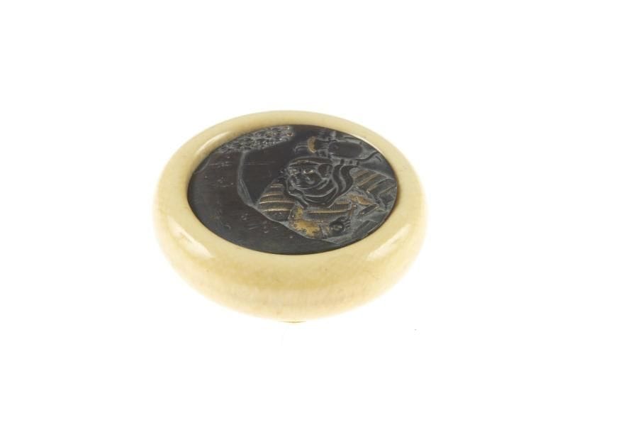 Kagamibuta, le bol en ivoire la plaque en shibuichi à décor ciselé d'un guerrier sous un cerisier en fleur. D. 5 cm.