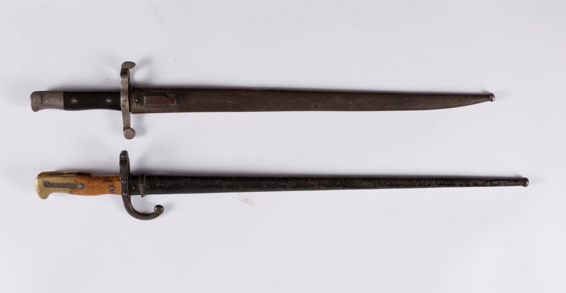 FRANCE – PORTUGAL 
Deux baïonnettes : 
- Portugal – baïonnette modèle 1885. Lame gravée « Steyr 1886 ». Fourreau en tôle de fer. 
- France – baïonnette modèle 1874. Dans l’état (piqûres, restaurations).